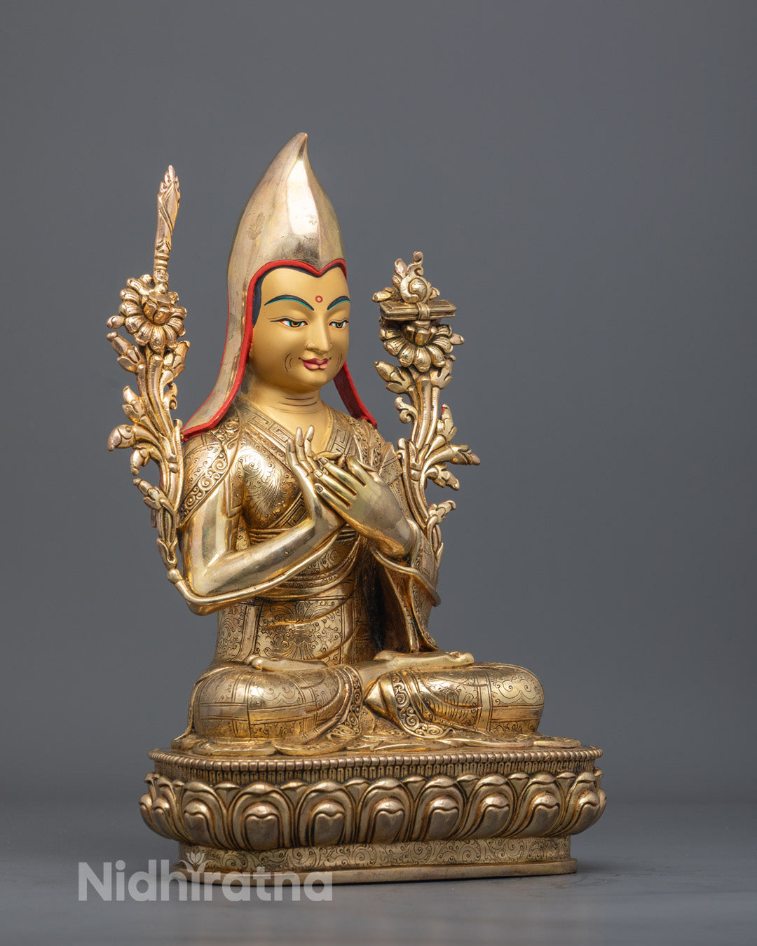 Close-up side angle of Je Tsongkhapa’s gold-gilded face and yellow Pandita hat carving.