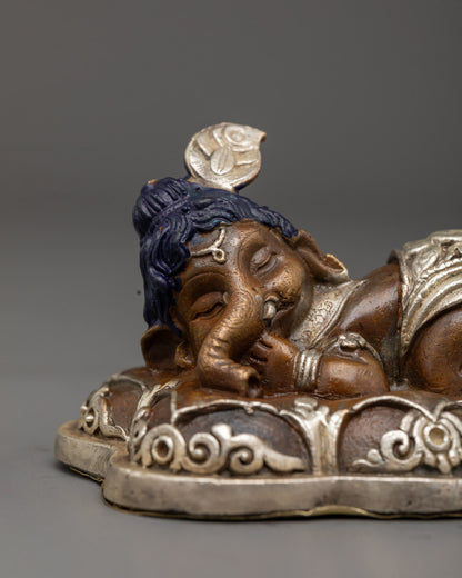 baby Ganesha idol resting peacefully, highlighting intricate detailing and traditional electroplating finish