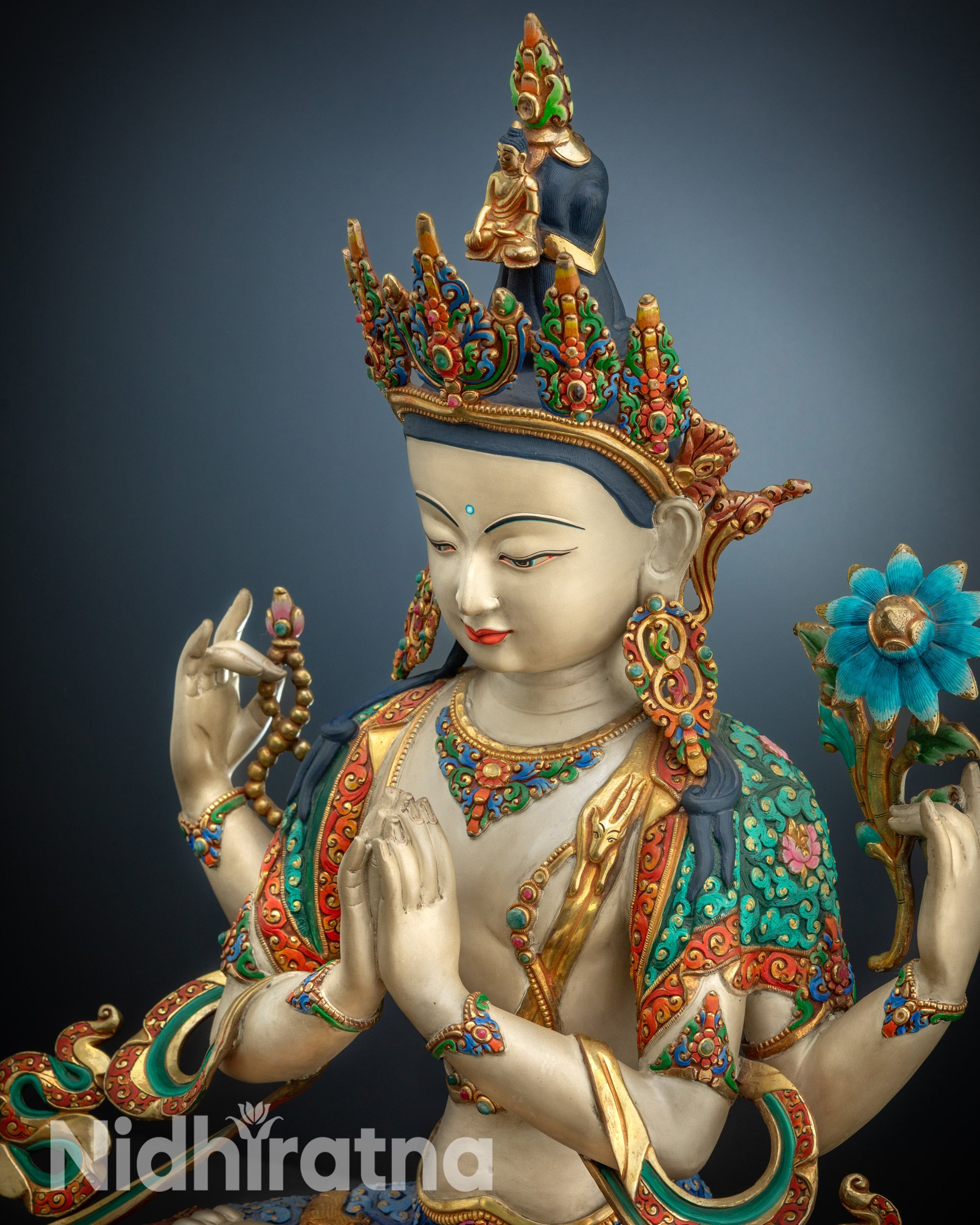 Close-up upper side view of Chenrezig statue with detailed crown and lotus ornament