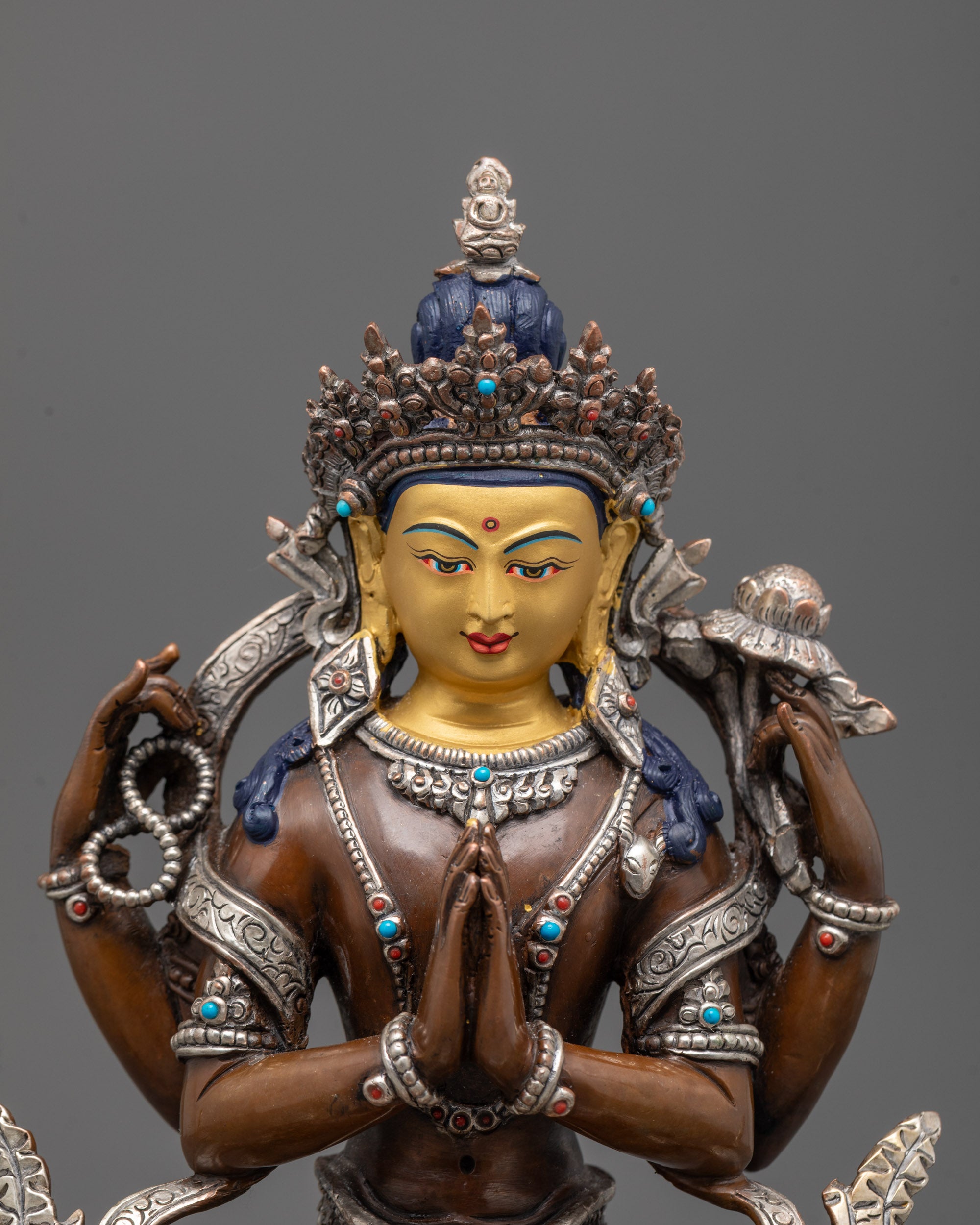 Close-up view of Chenrezig statue’s intricate craftsmanship featuring semi-precious stones