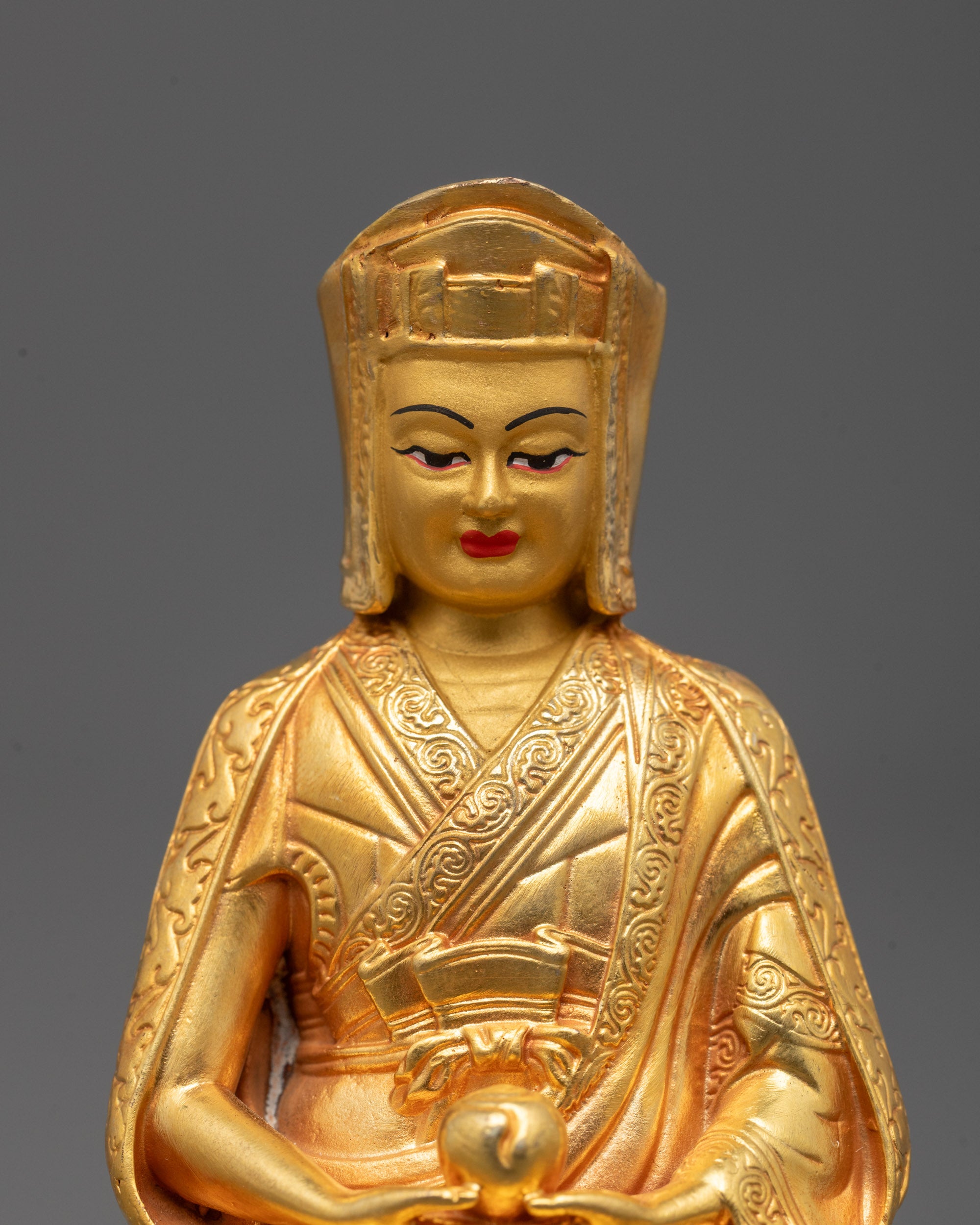 Close-up view of Gampopa Statue face with serene expression showing detailed electroplating