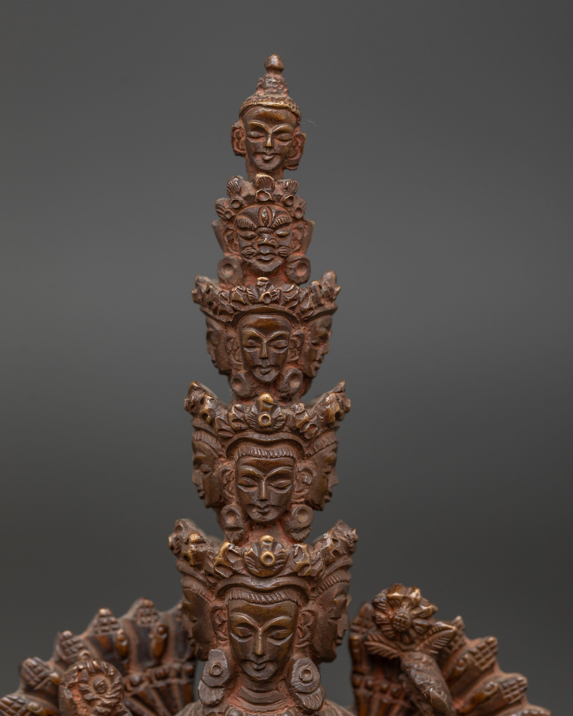 Close up 1000-Armed Avalokiteshvara statue showing eyes in palms and intricate copper details