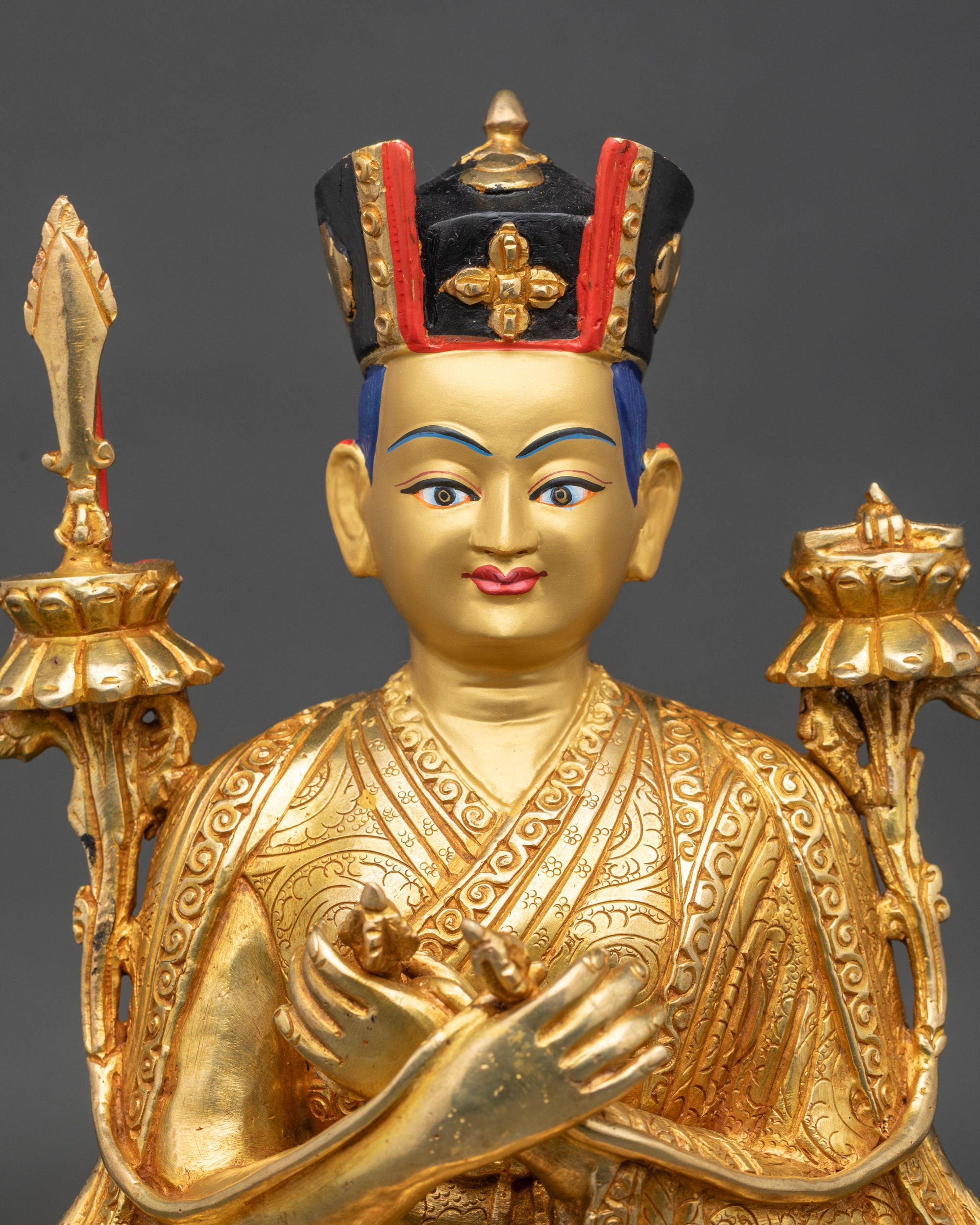 Close up 16th Karmapa face with serene expression and intricate monk robe carvings