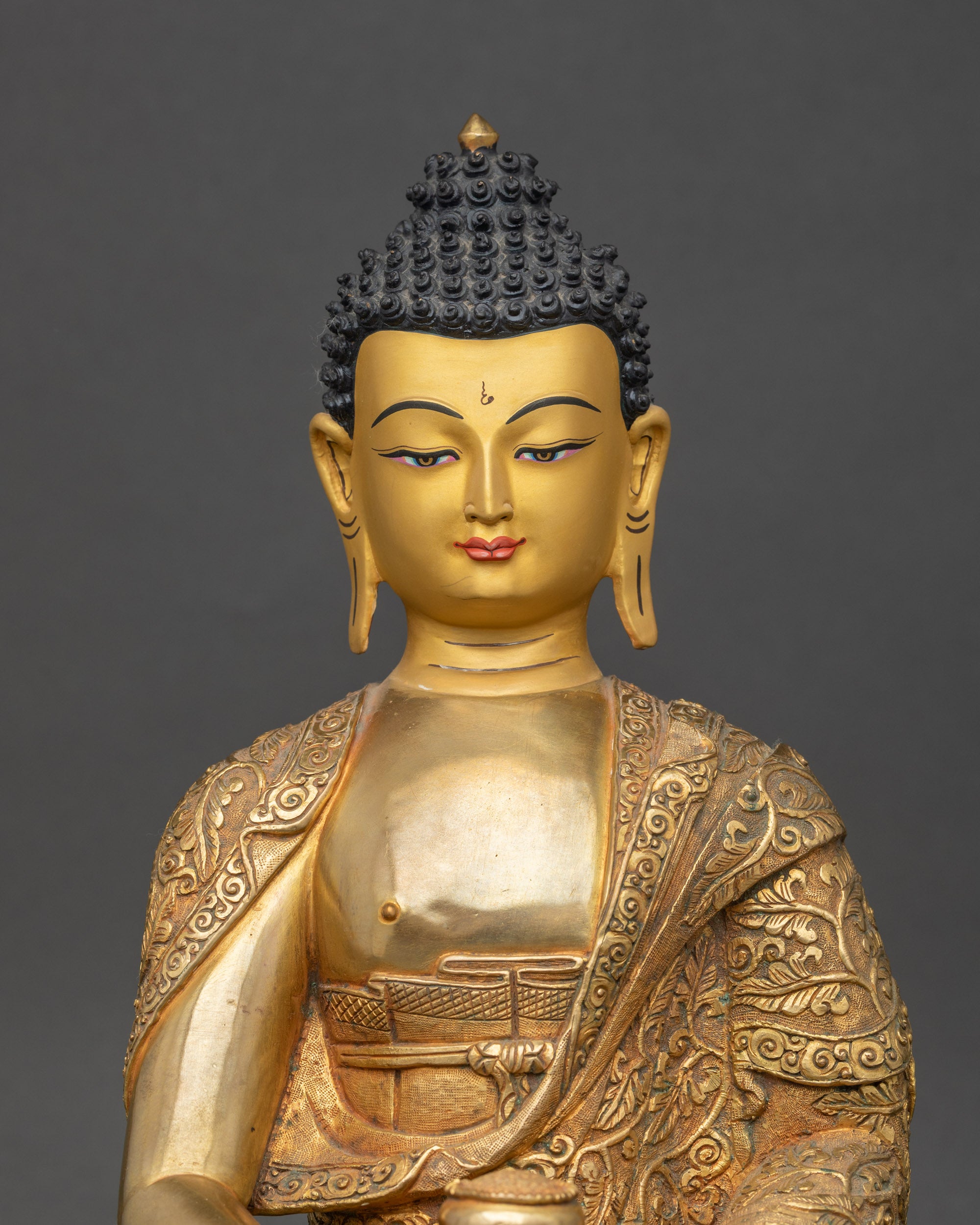 Close up Amitabha Buddha face with gold paint, holding alms bowl, handcrafted sacred statue