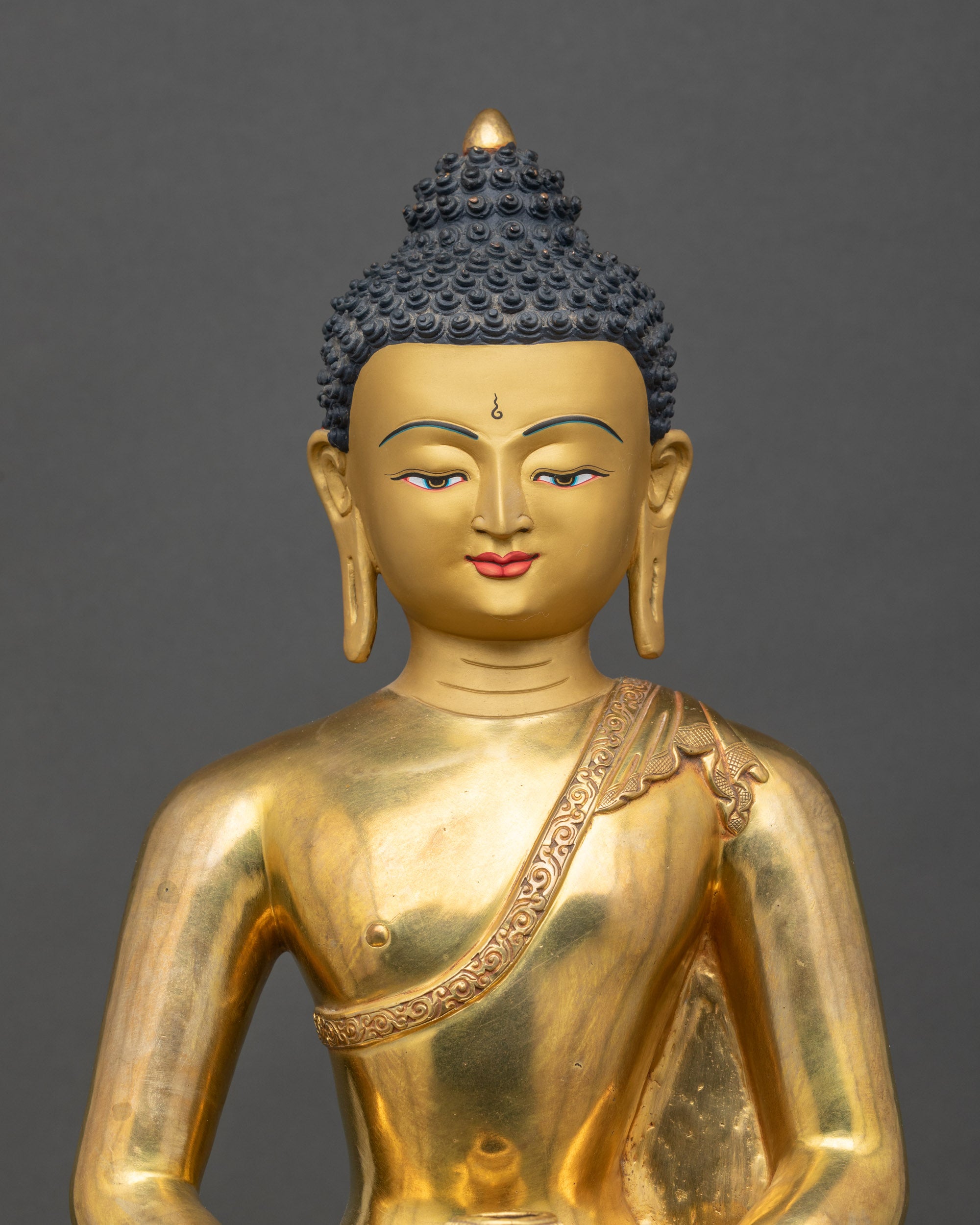 Close up Amitabha Buddha gold-painted face, handcrafted Nepalese Mahayana Buddhist statue