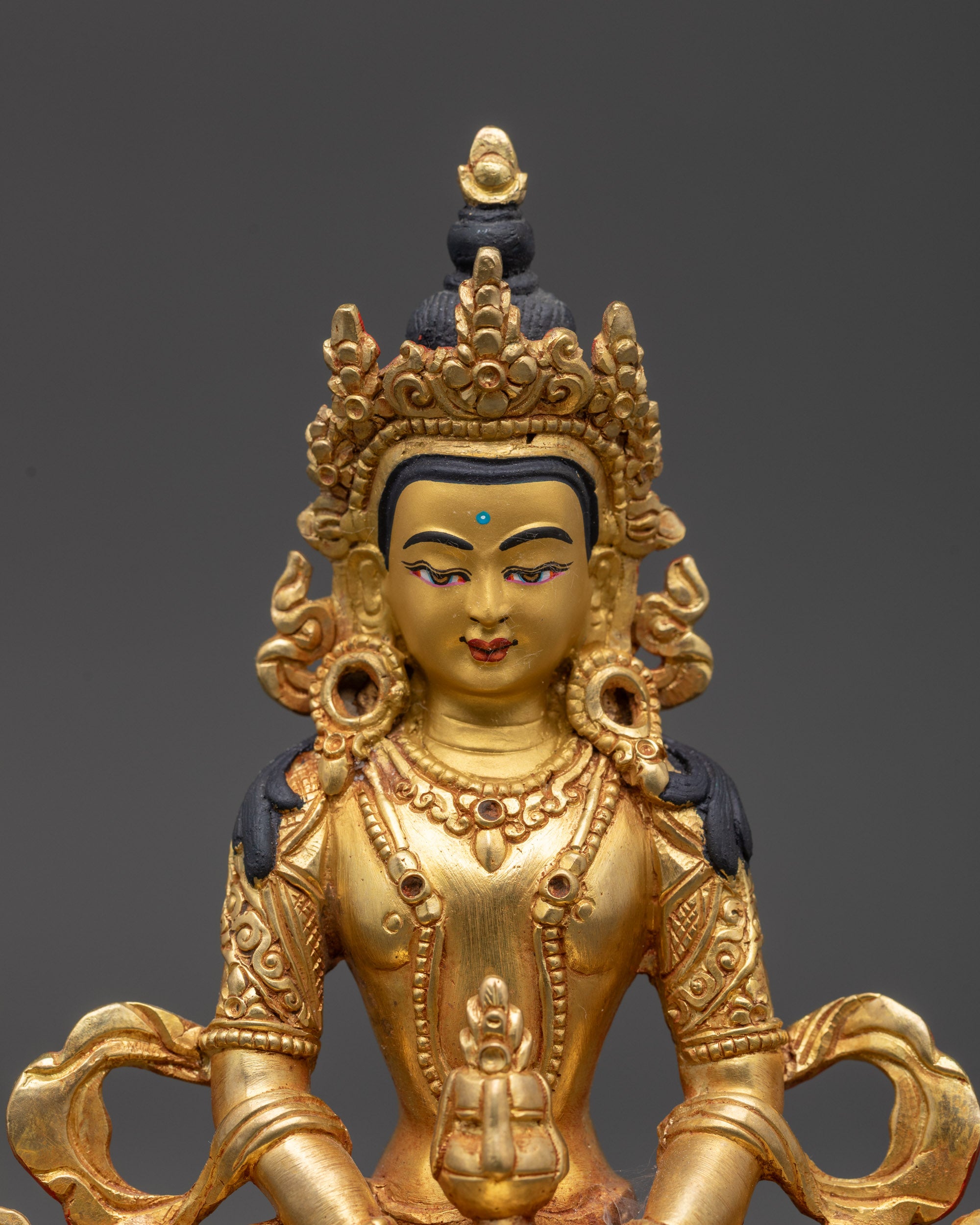 Close up Amitayus Buddha figurine showing intricate earrings and armlets