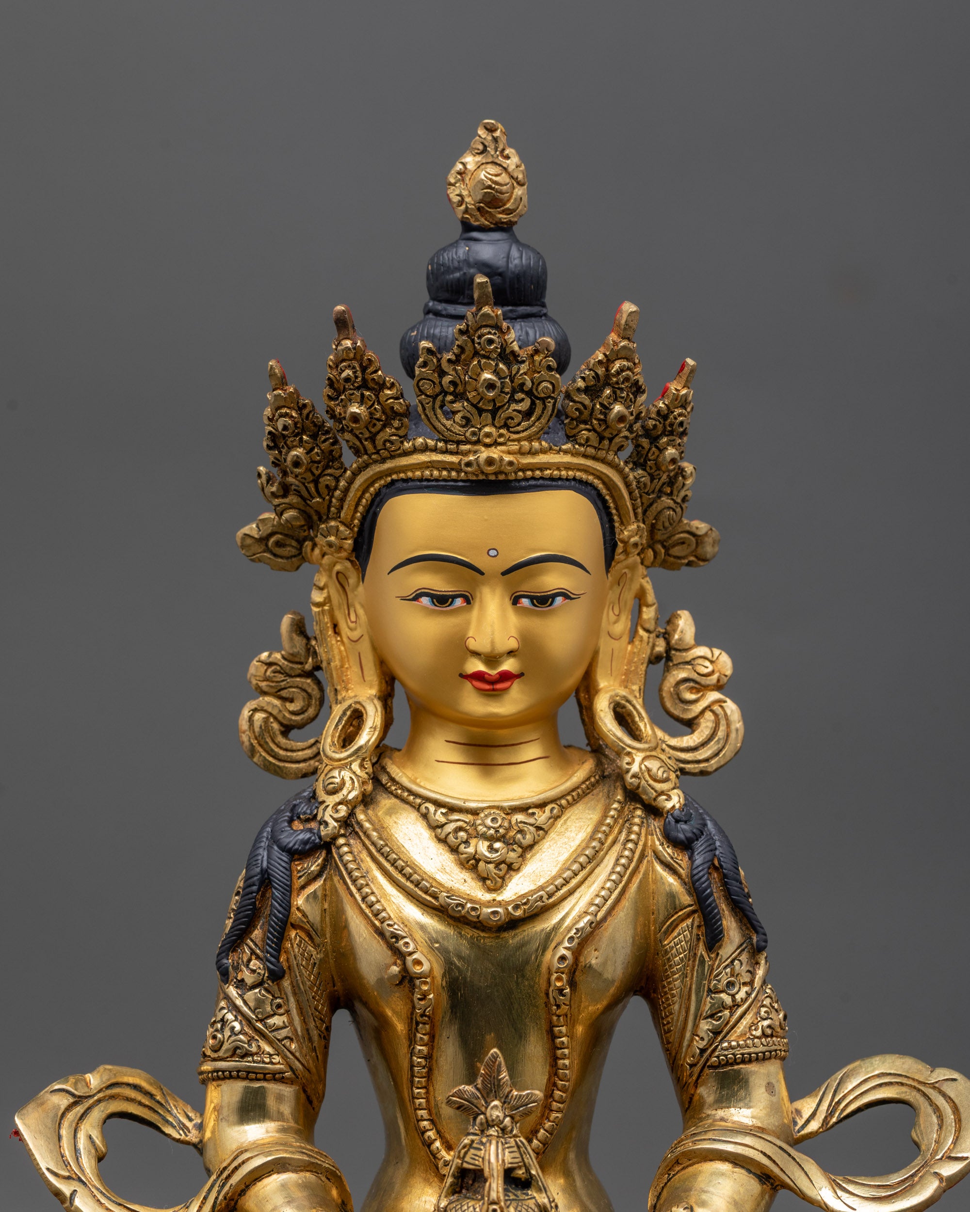 Close up Amitayus Statue face with five jewel crown and serene Tibetan long life deity
