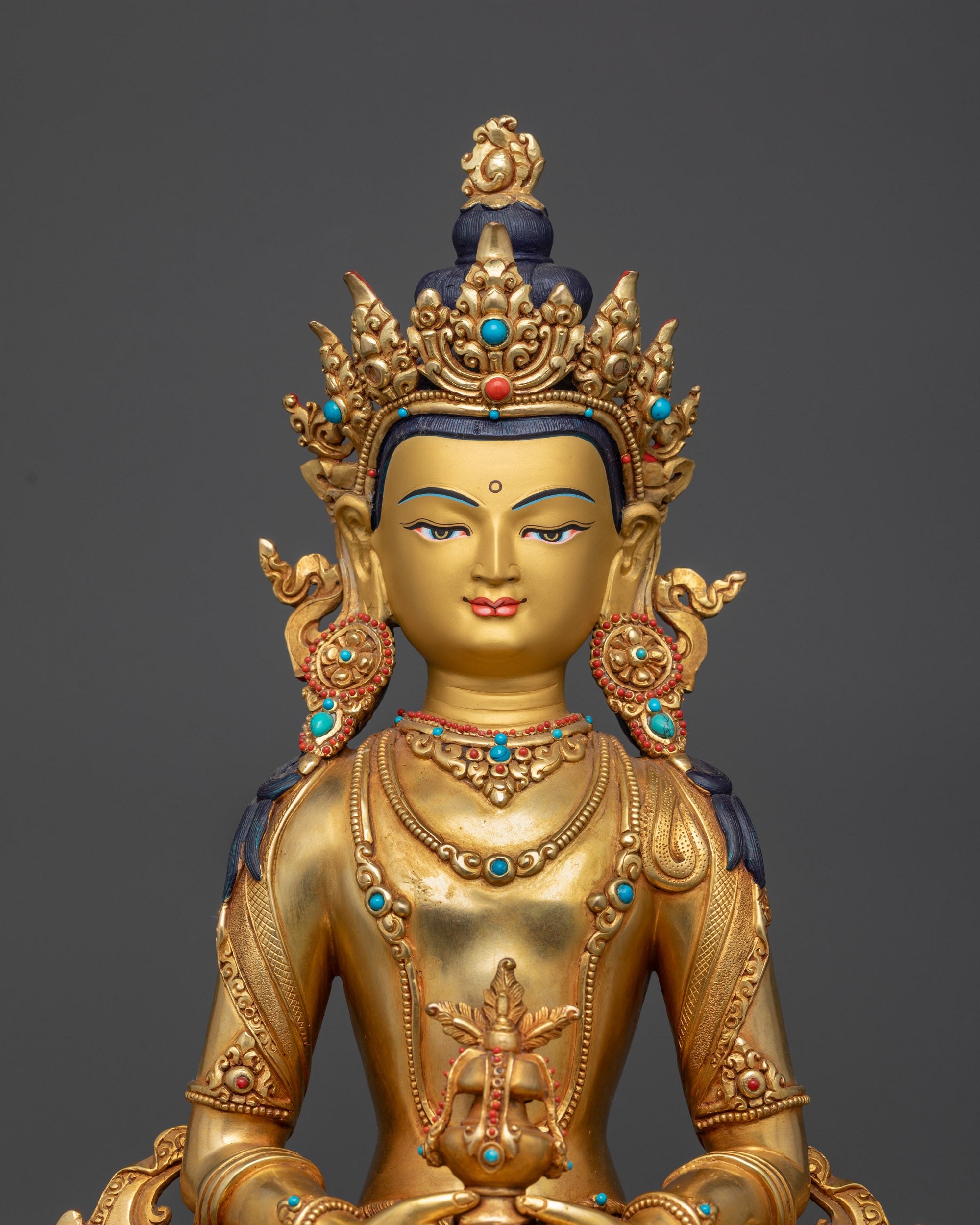 Close up Amitayus gold-gilded face with jeweled crown and serene expression