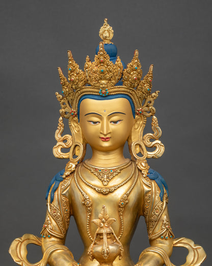 Close up Amitayus statue gold-painted face adorned with semi-precious stones handmade in Nepal