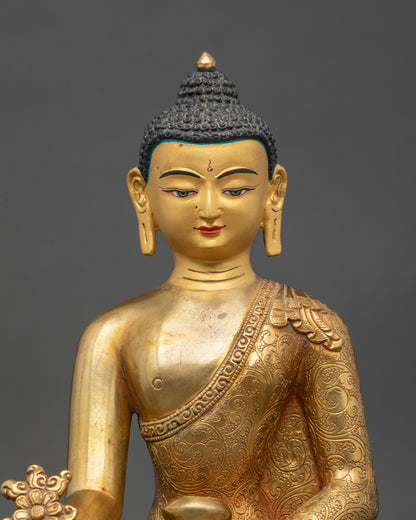 Close up Bhaisajyaguru gold-painted face showing serene expression and meditation symbol