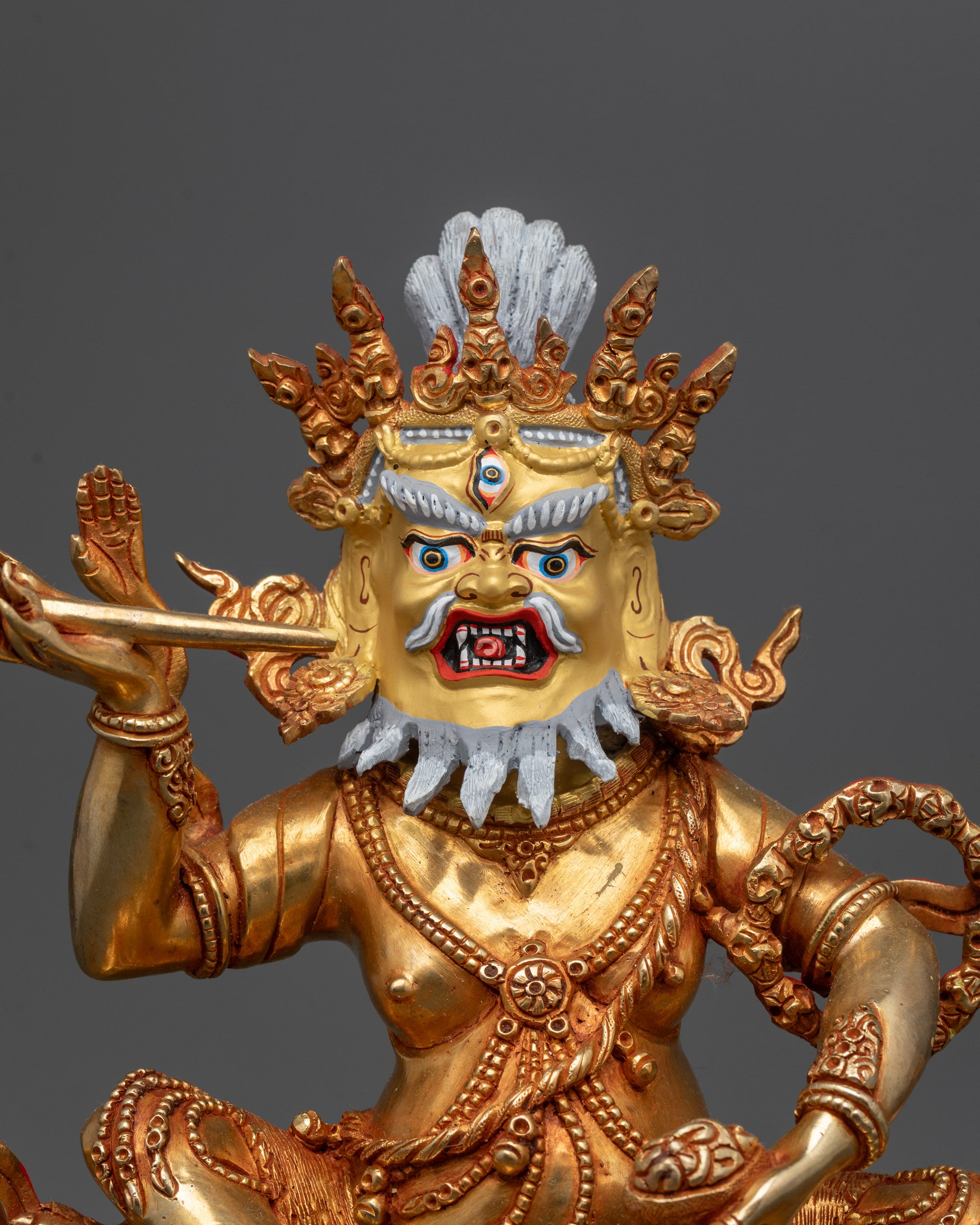 Close up Brahmanrupa Mahakala Statue showing gold-gilded face third eye and skull cup