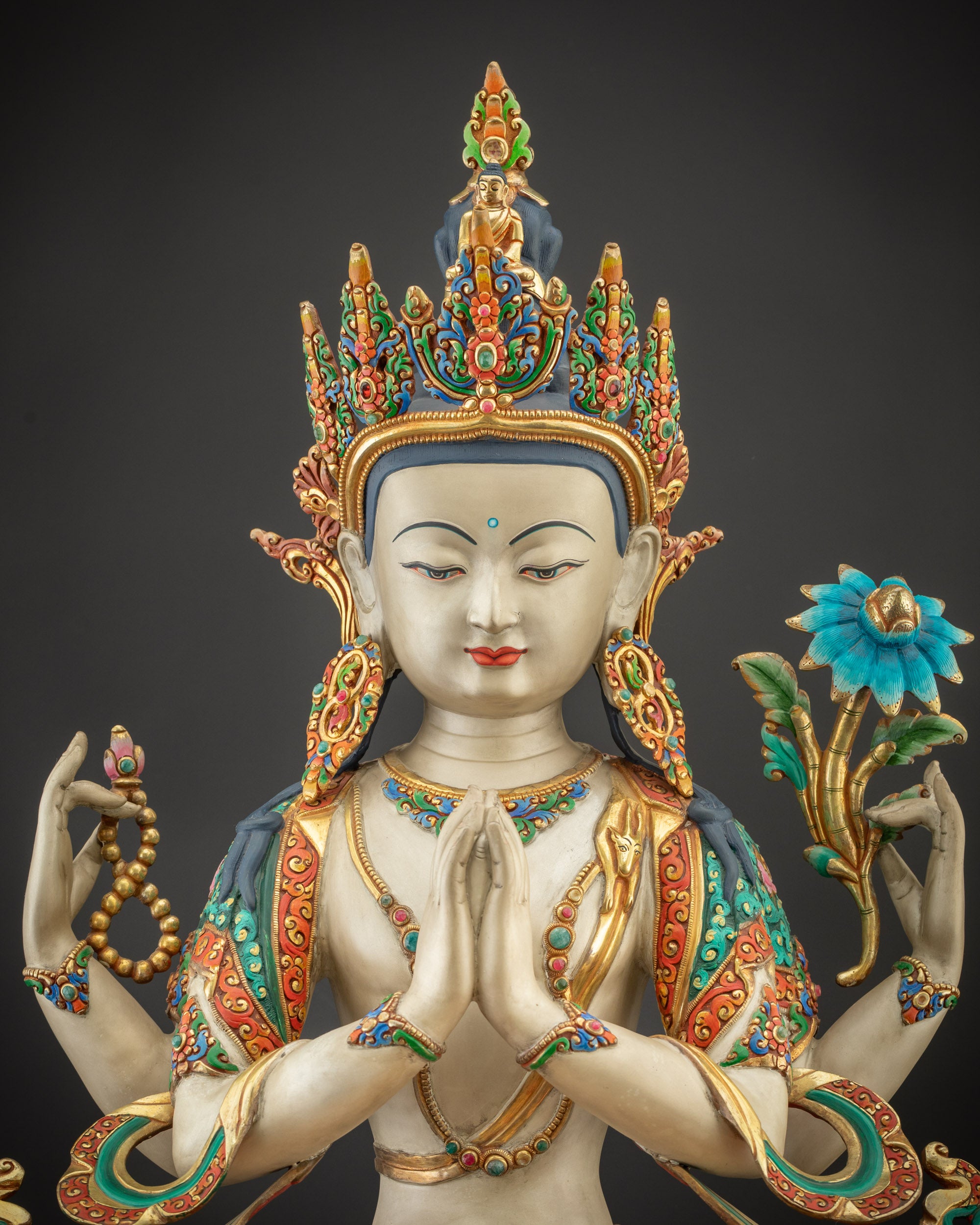 Close up Chenrezig Statue displaying gold-plated robes and semi-precious stone details