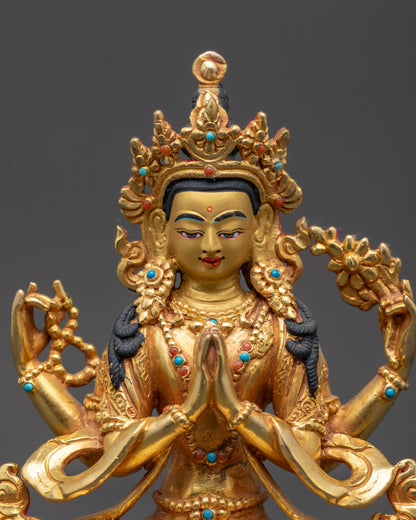 Close up Chenrezig Statue showing serene face, detailed robes, and gold fire-gilding
