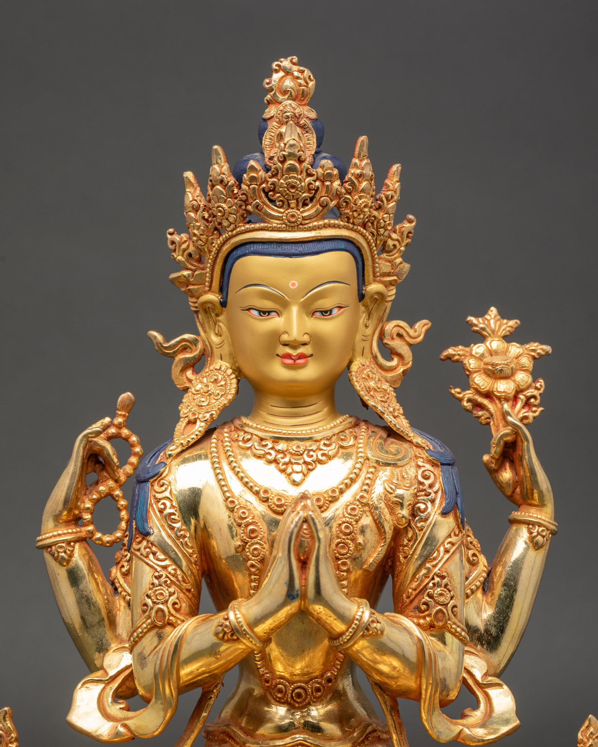 Close up Chenrezig golden face four arms Bodhisattva of Compassion Himalayan art