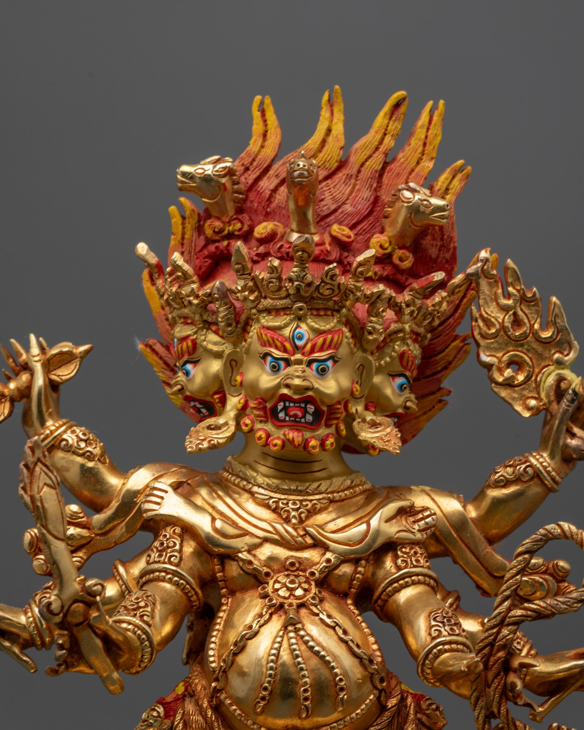 Close up Dharmapala Statue showing intricate details and multiple arms wielding sacred objects

