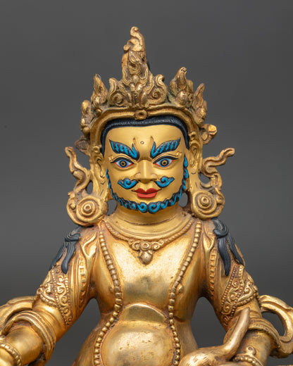 Close up Dzambhala Buddha gold-painted face showing serene expression and wealth symbolism