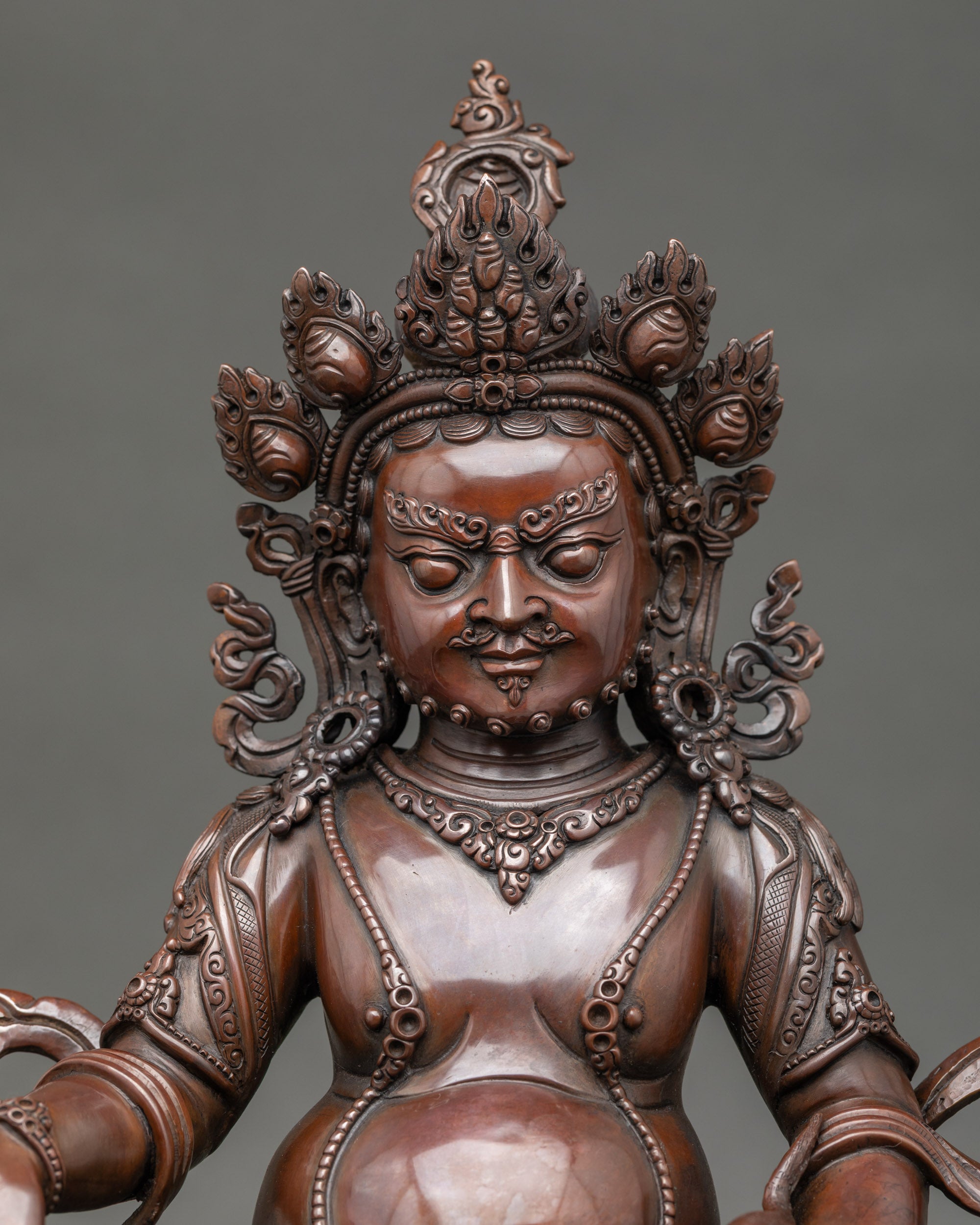 Close up Dzambhala Buddha sculpture with crown and ornate jewelry, handmade in Patan, Nepal