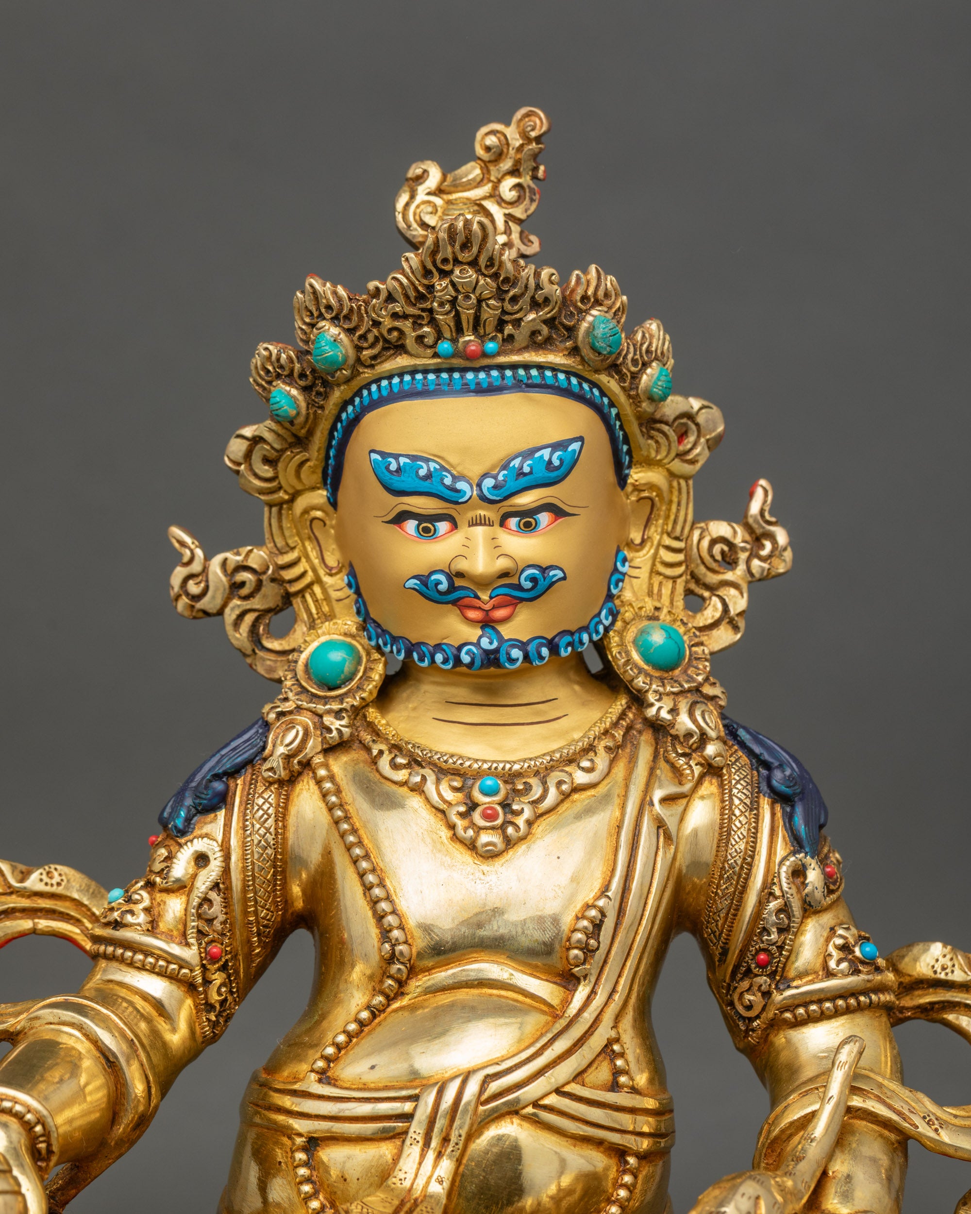 Close up Dzambhala sculpture gold-painted face semi-precious stones Newari craftsmanship