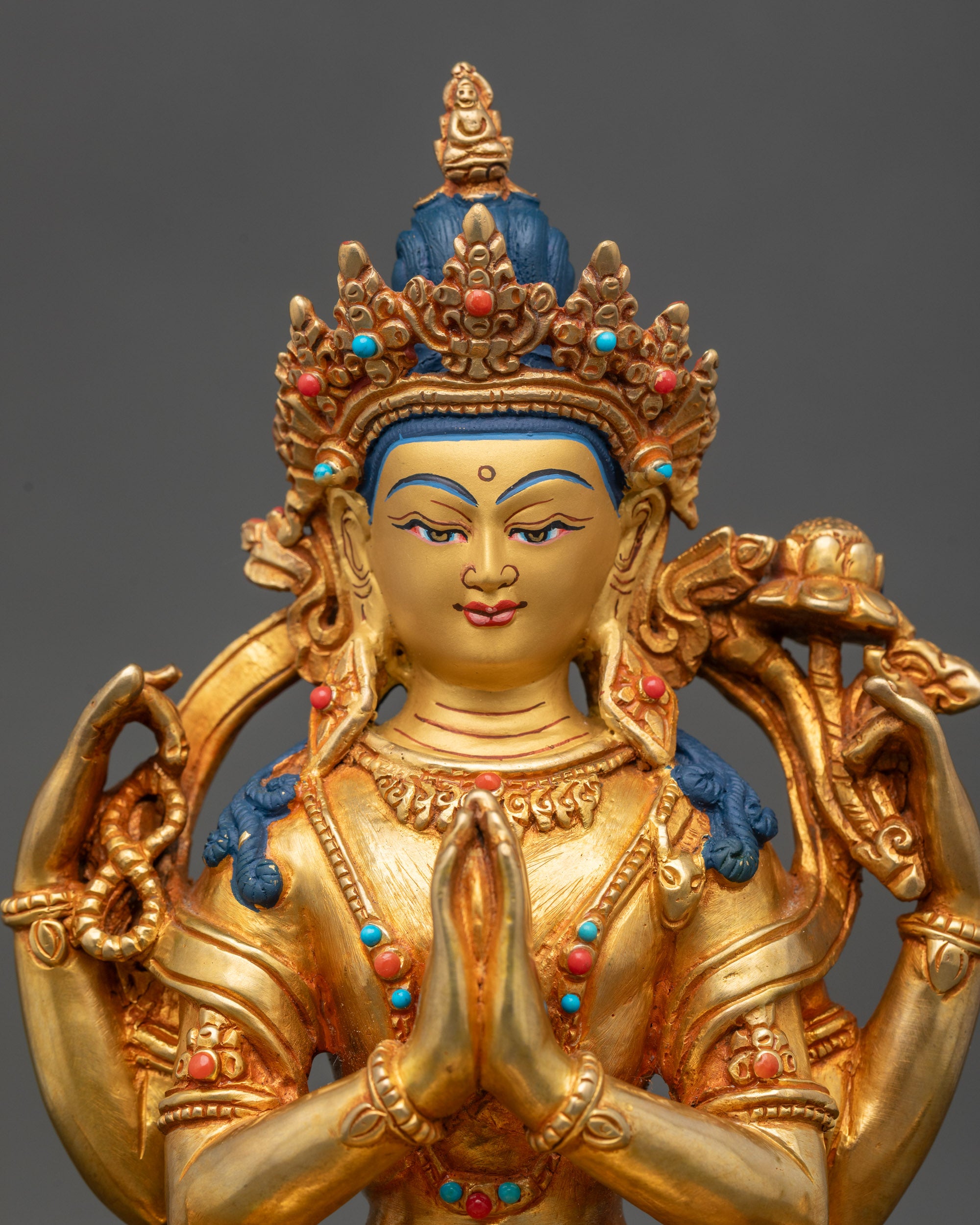 Close up Green Tara face, gold-painted with coral and turquoise stones, handcrafted Nepal art