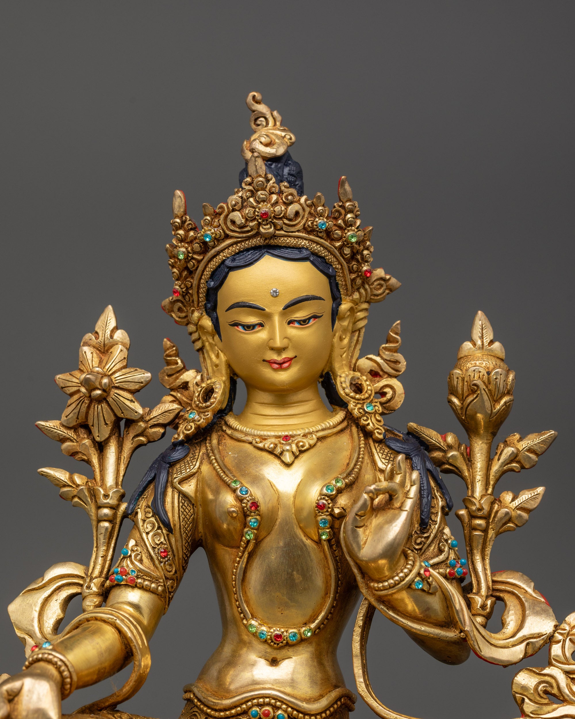 Close up Green Tara holding utpala flower, adorned with semi-precious stones