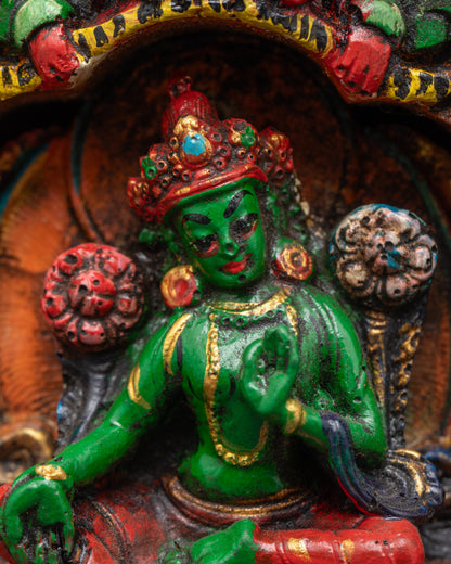 Close up Green Tara seated on lotus in wooden frame with garuda throne