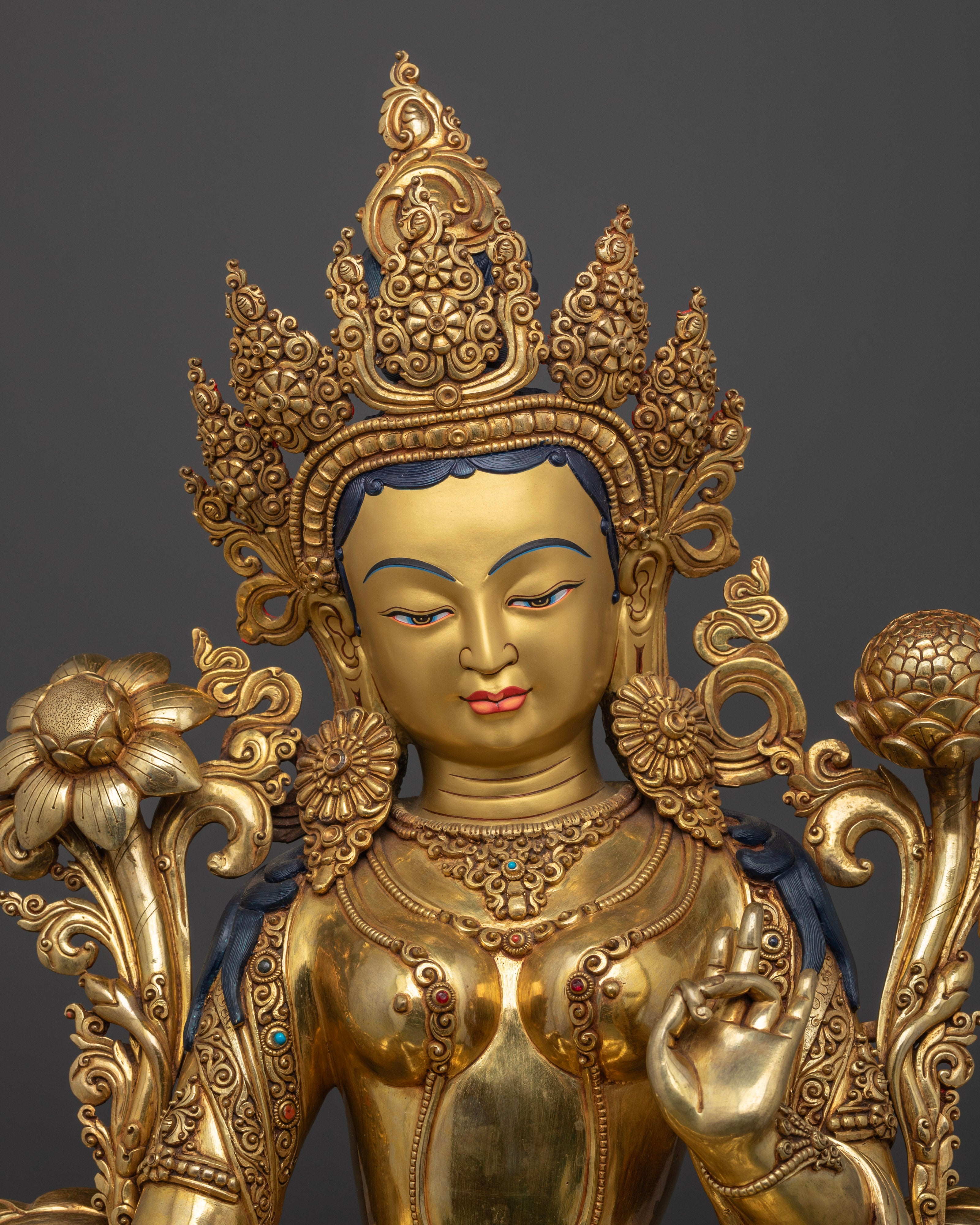 Close up Green Tara serene face with intricate carvings and Utpala lotus stem, handmade Himalayan Buddhist art