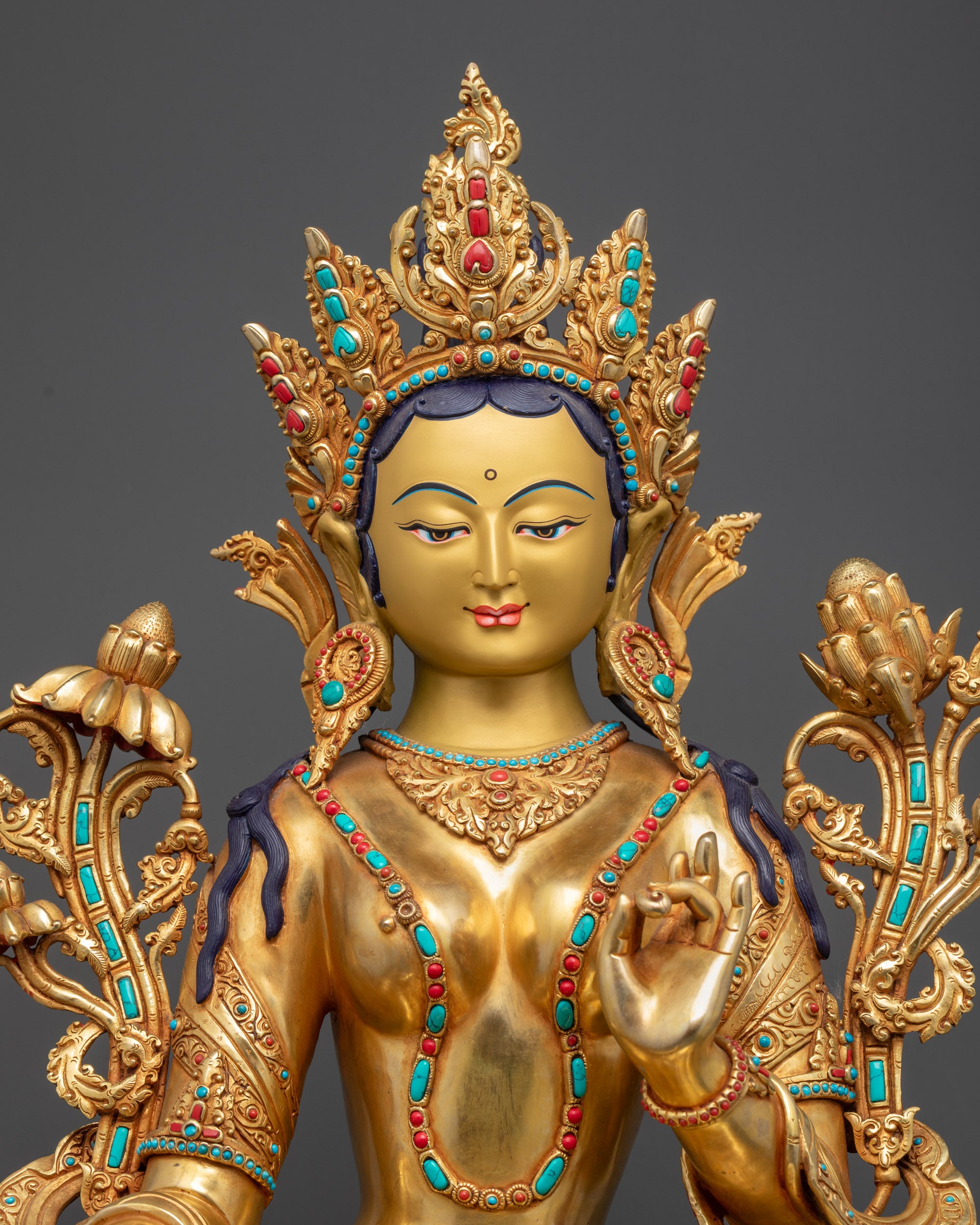 Close up Green Tara statue semi-precious stones and gold fire-gilded details