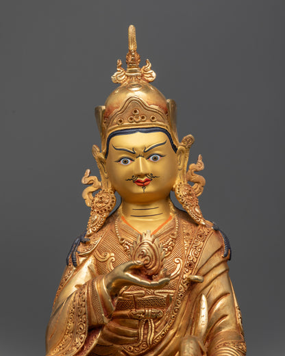 Close up Guru Norlha statue gold gilded face with conch shell and carved robe details