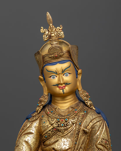 Close up Guru Padmasambhava gold-painted face with wrathful yet compassionate expression, hand-carved Himalayan sculpture