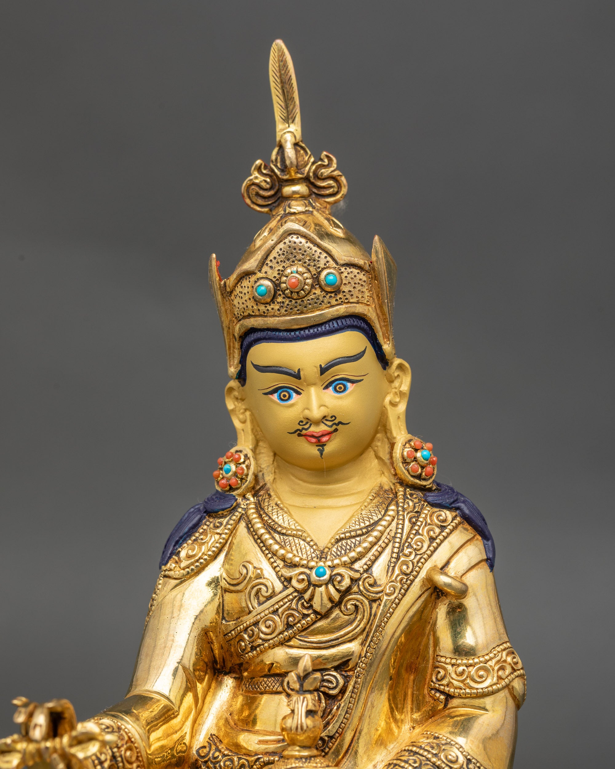 Close up Guru Padmasambhava statue showing lotus crown vulture feather details