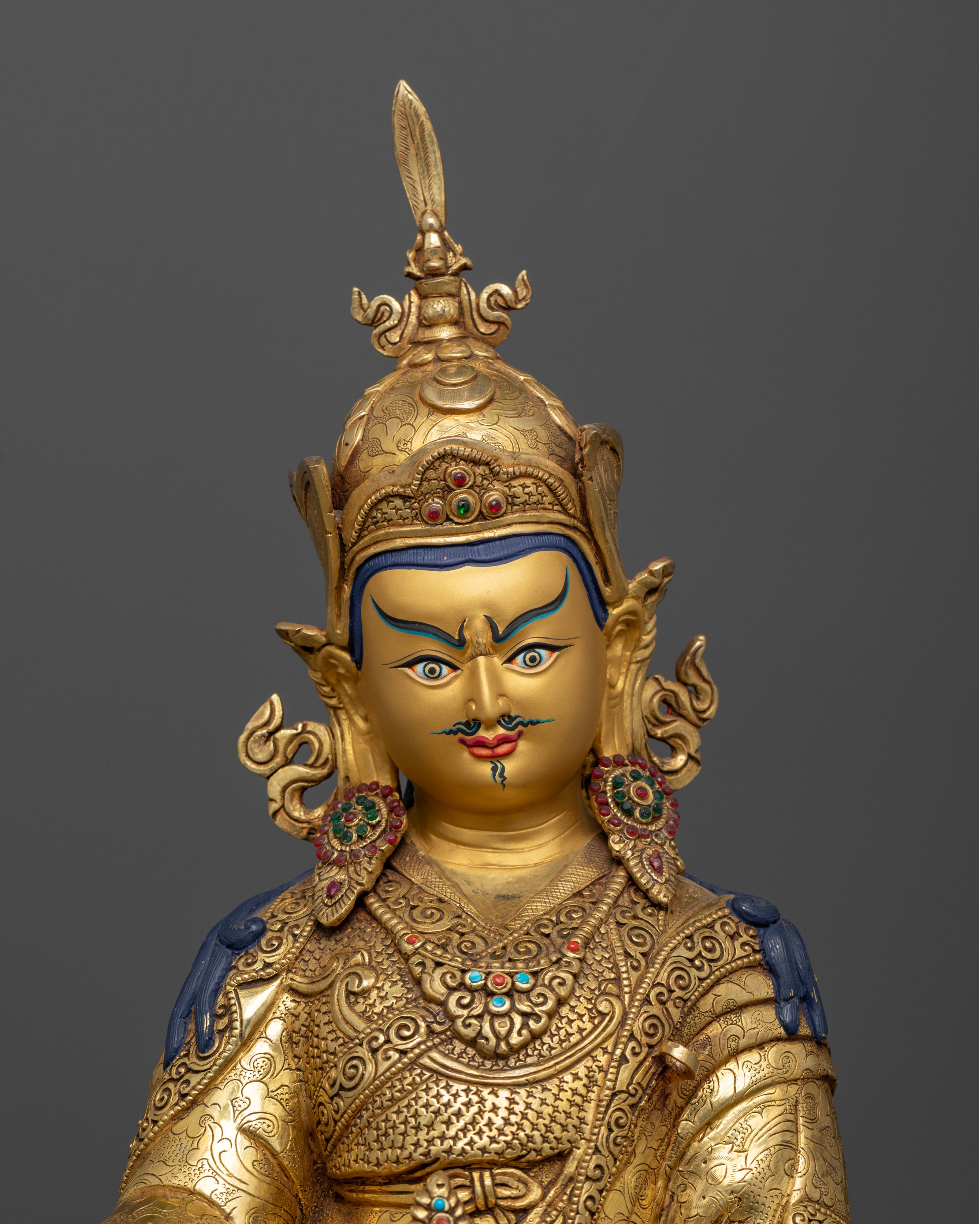 Close up Guru Rinpoche gold-painted face with semi-precious stones, hand-carved Newari Himalayan Buddhist art