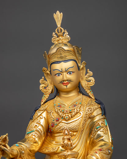 Close up Guru Rinpoche statue gold-gilded face wearing lotus crown with detailed carving