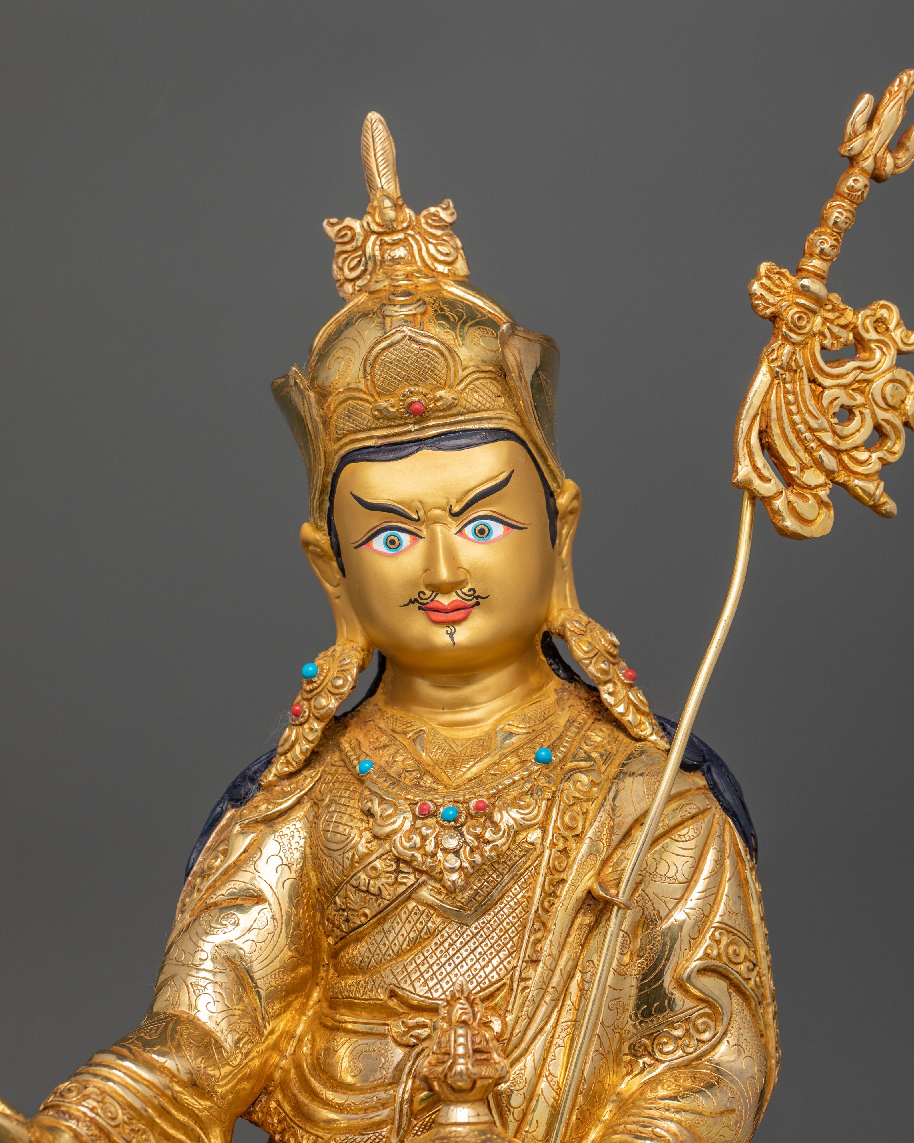 Close up Guru Rinpoche statue gold-painted face Vajra Kalash lotus hat details