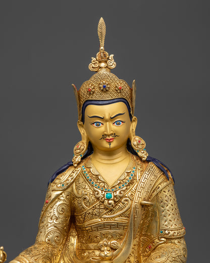 Close up Guru Rinpoche statue showing intricate robes and semi-precious stones