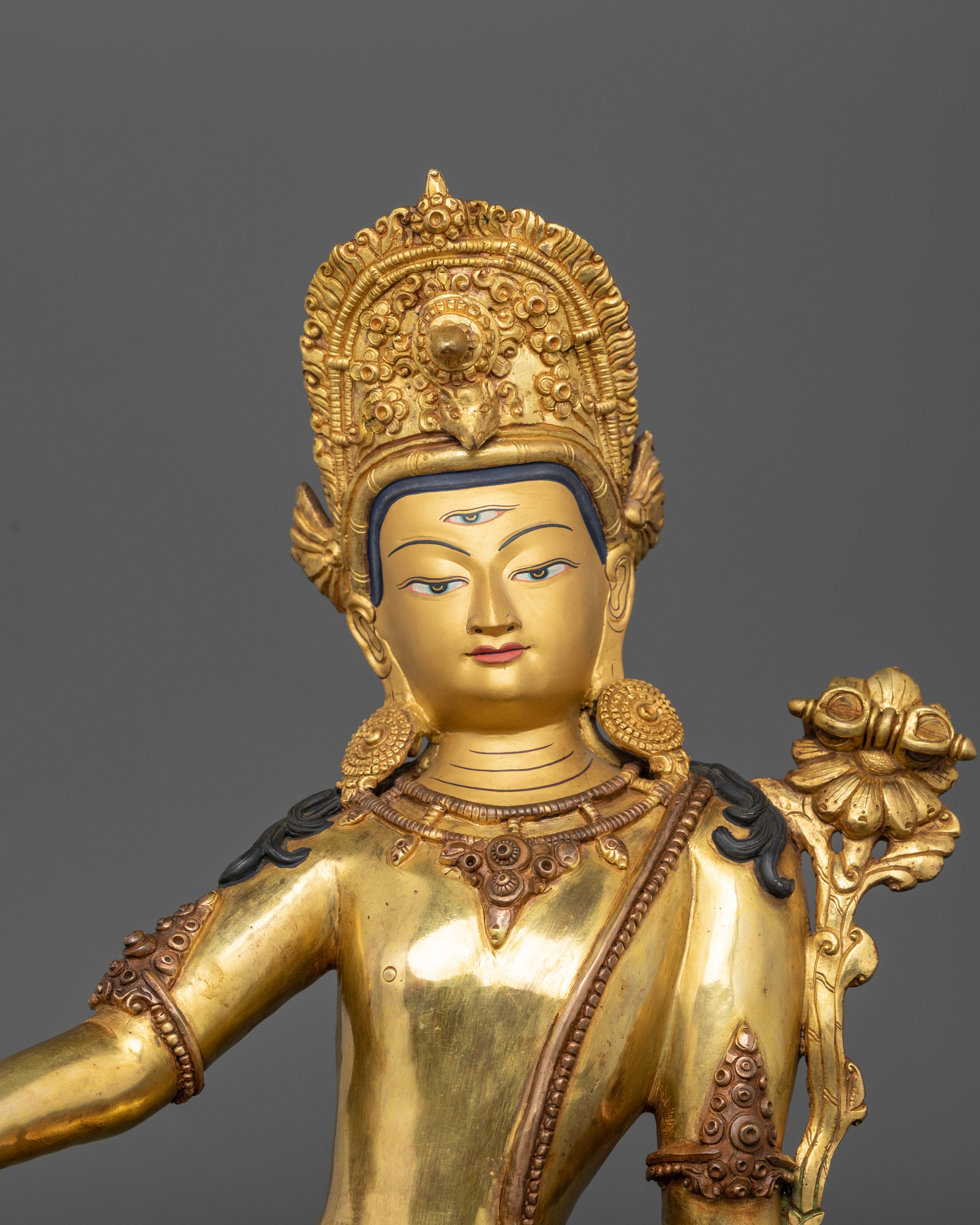 Close up Indra gold-painted face third eye tall crown divine jewelry details