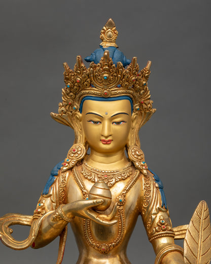 Close up Ksitigarbha statue showing gold-painted face, copper-gold detailing, and sacred stones