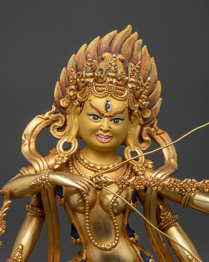 Close up Kurukulla statue showing third eye, five-skull crown, and sacred objects in hands
