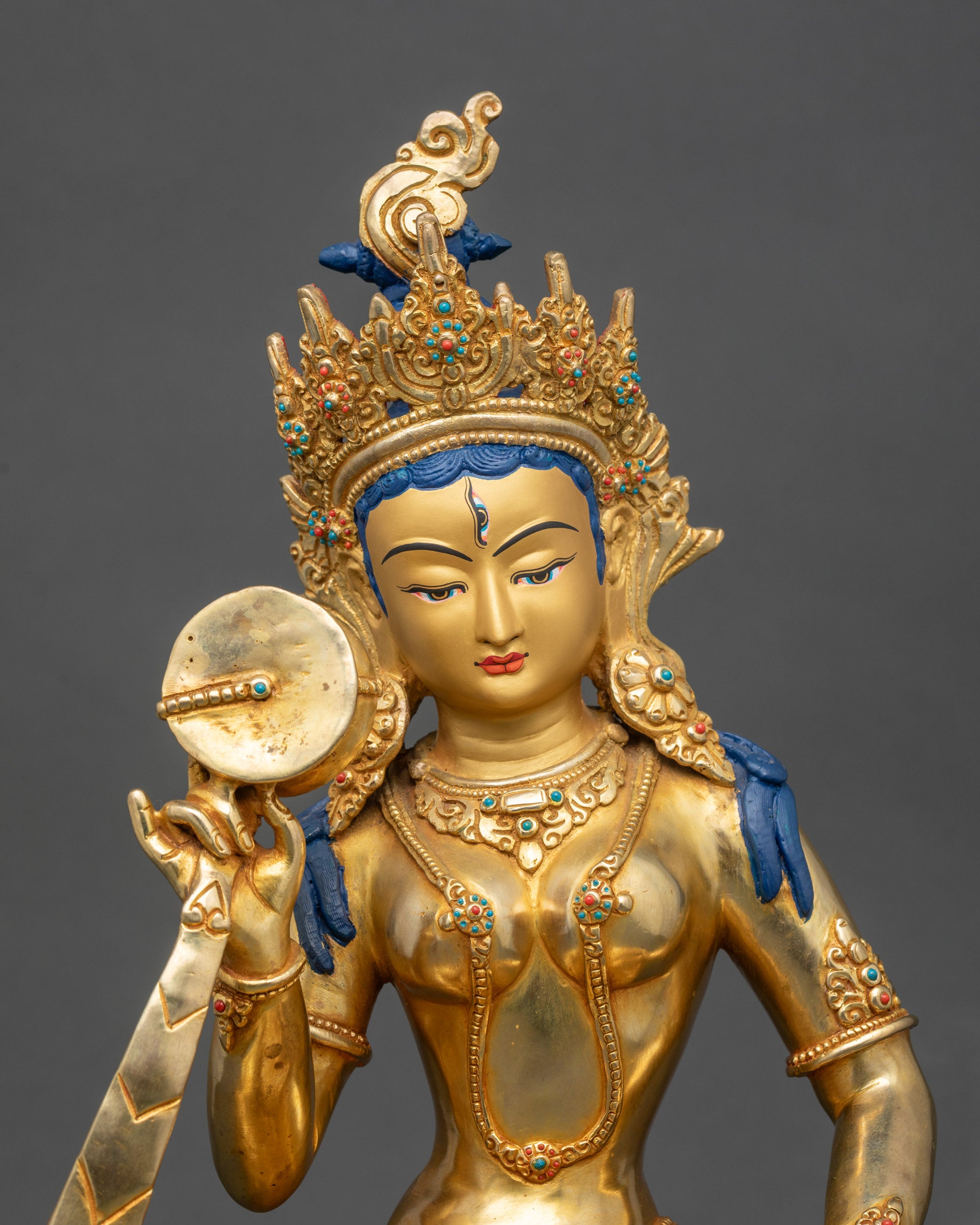 Close up Machig Labdron face, gold-painted, five-pointed crown and third eye visible