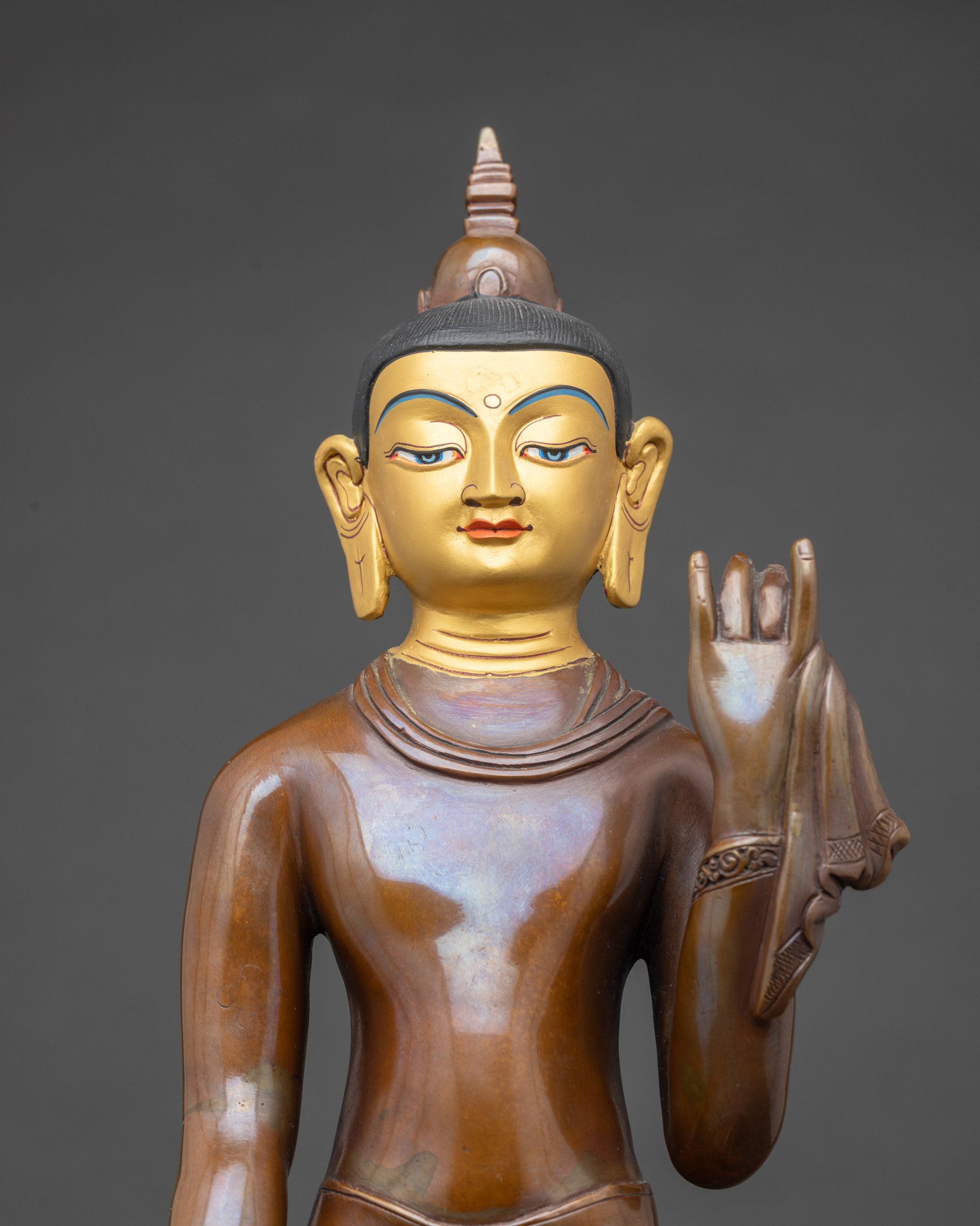 Close up Maitreya Buddha face gold-painted face oxidized copper Buddhist statue handmade Nepal