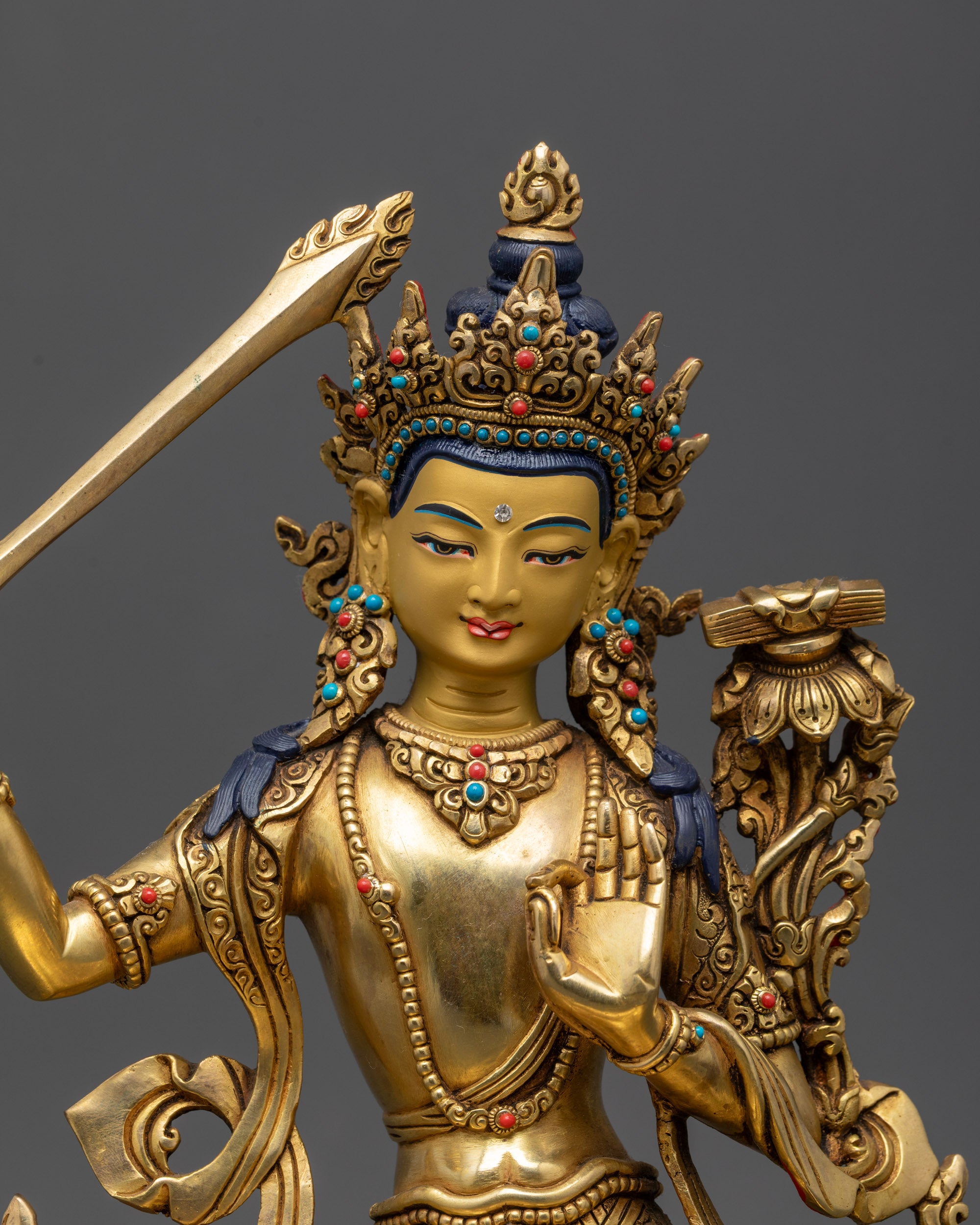 Close up Manjushree gold-gilded face with peaceful expression and carved robes