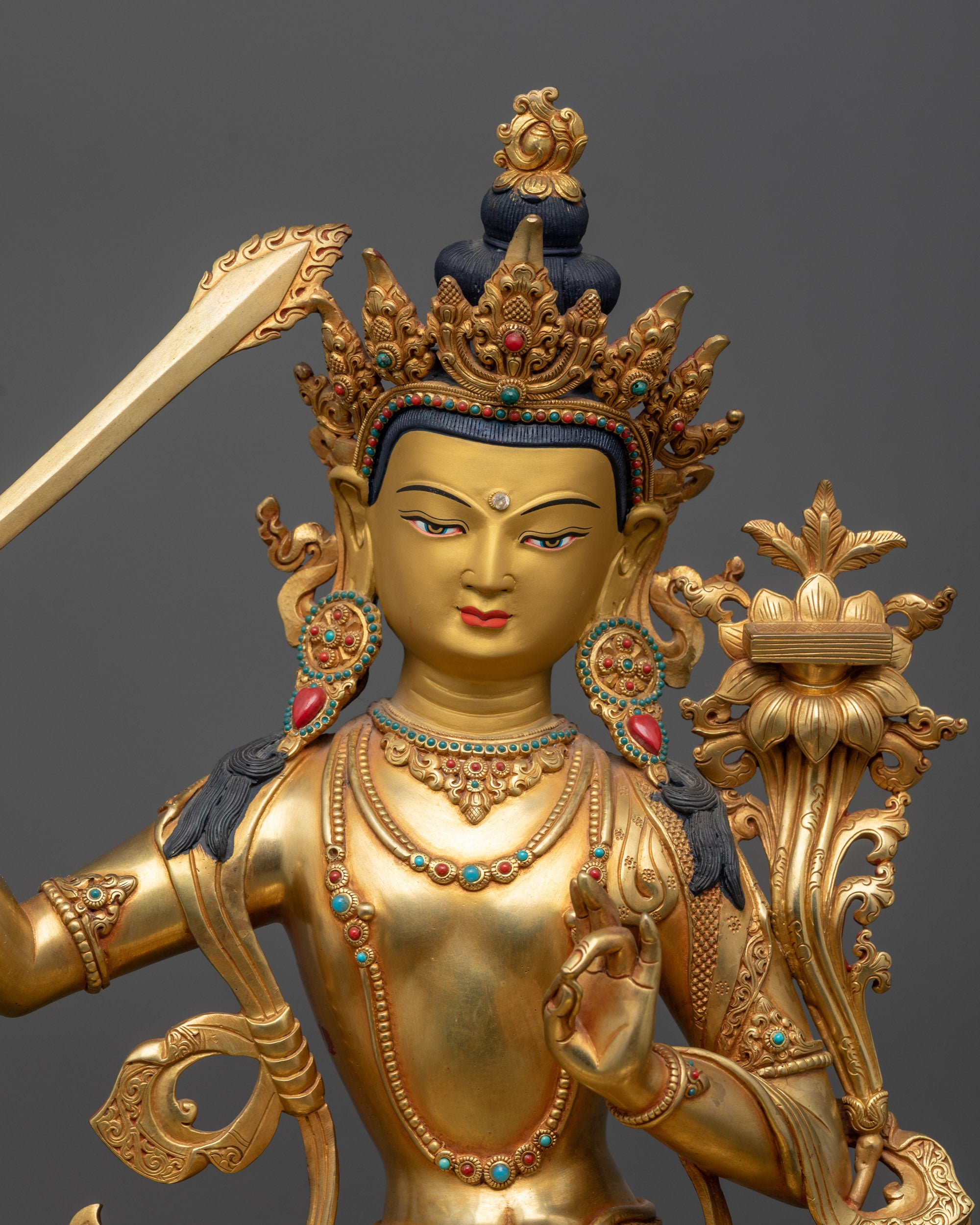 Close up Manjushri gold-gilded face with peaceful expression and majestic halo