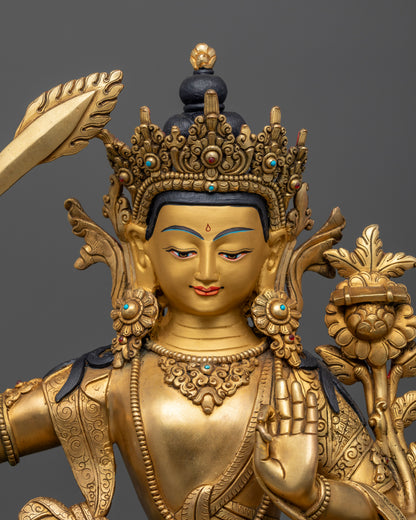 Close up Manjushri gold-painted face with wisdom sword and Utpala flower supporting Prajnaparamita Sutra, Himalayan sculpture