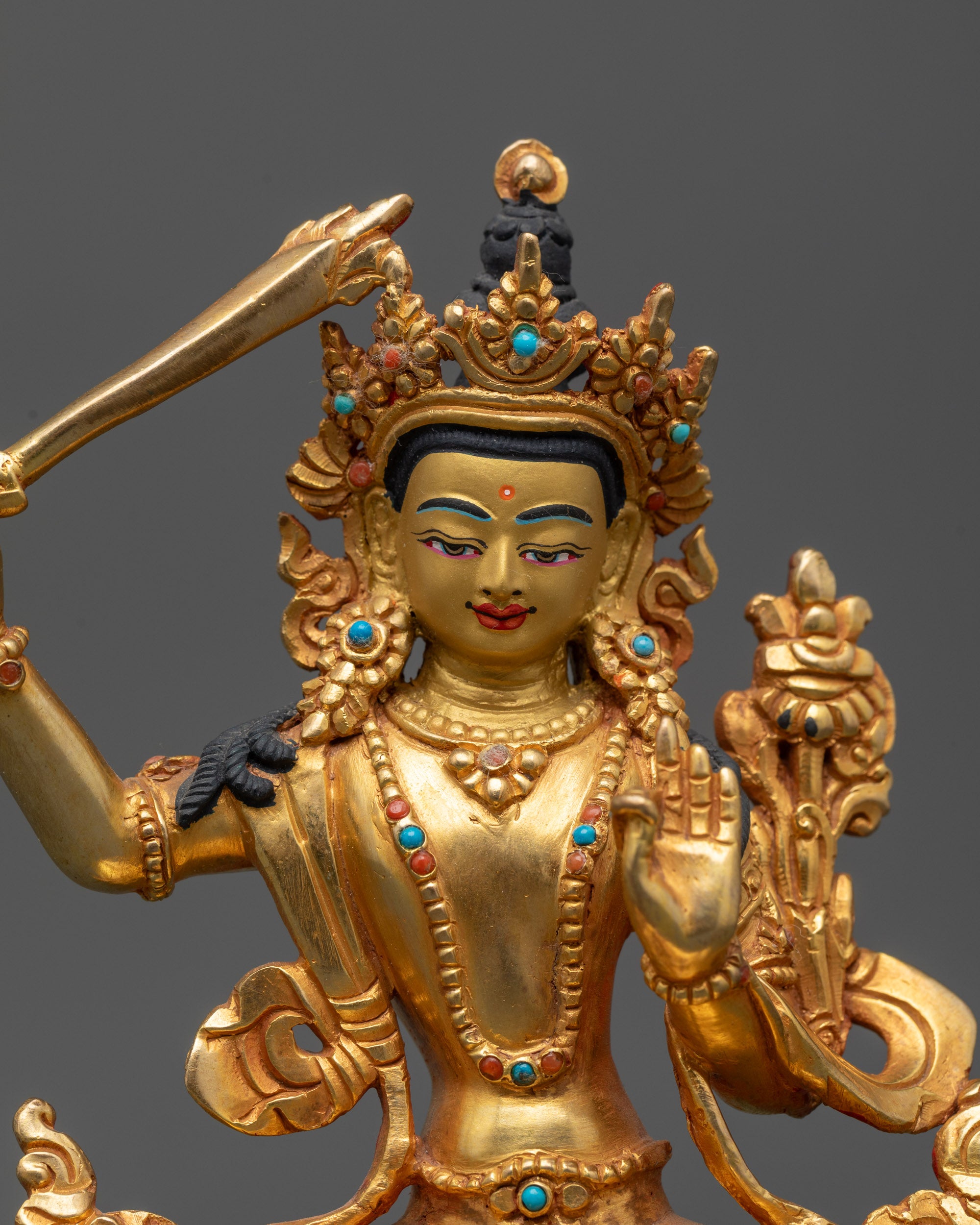 Close up Manjushri holding sword with wisdom flame and utpala stem

