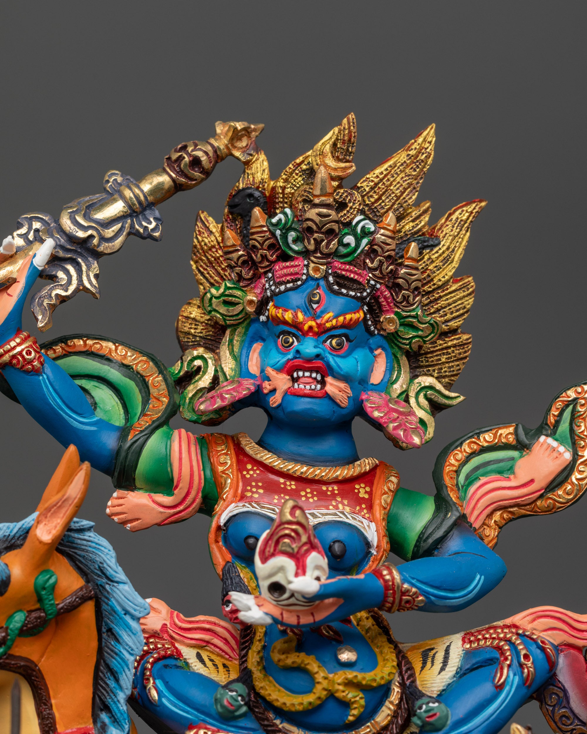 Close up Palden Lhamo statue showing five-skull crown and painted details
