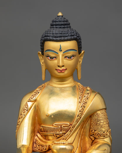 Close up Shakyamuni Buddha gold-painted face and detailed robe Patan Nepal sacred art