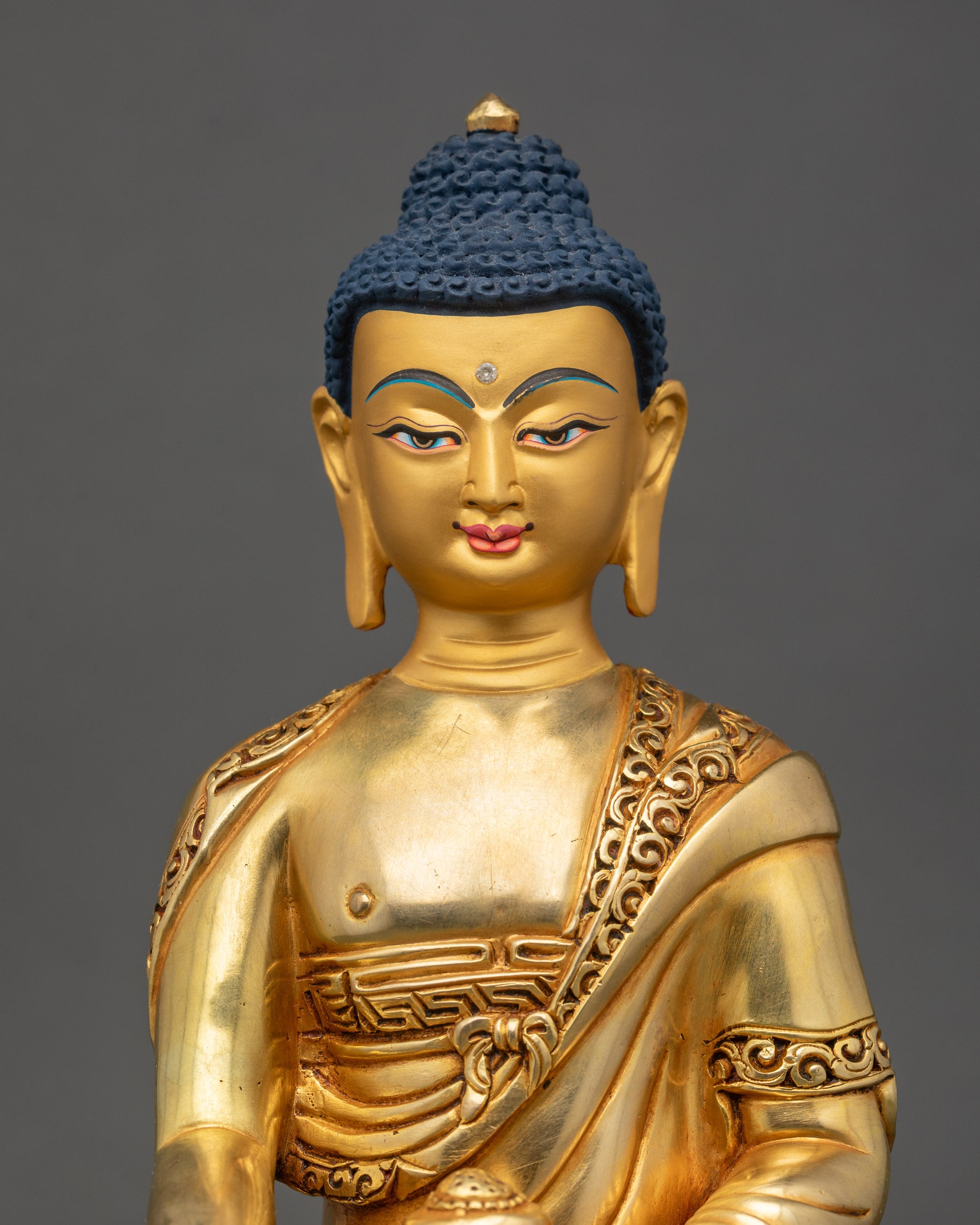 Close up Shakyamuni Buddha gold-painted face, handmade Newari Buddhist sculpture