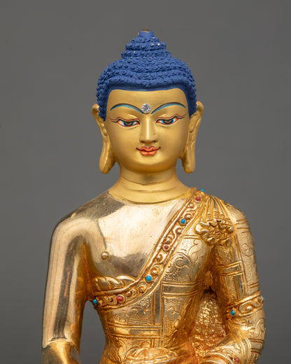 Close up Shakyamuni Buddha gold-painted face with semi-precious stone decoration