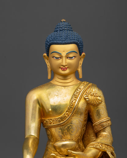 Close up Shakyamuni Buddha gold fire-gilded face and intricate robe details