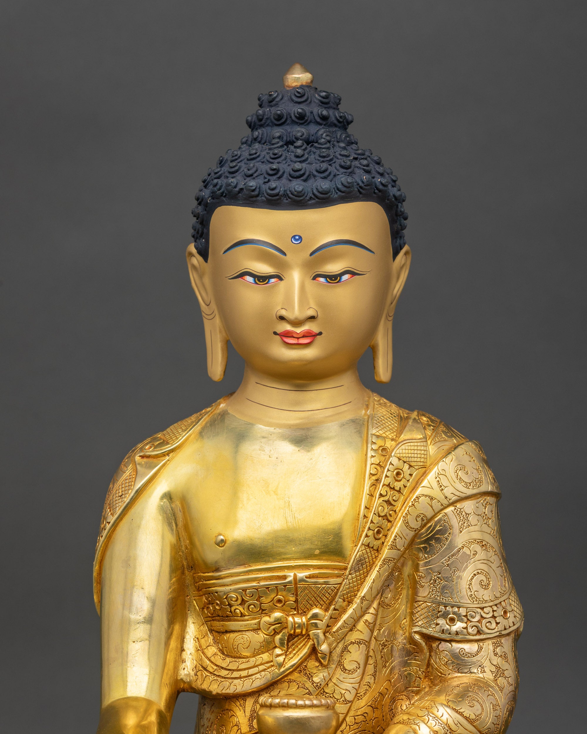 Close up Shakyamuni Buddha sculpture gold-painted face handmade Newari artisan Nepal