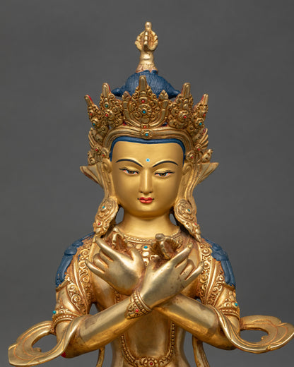 Close up Vajradhara statue showing gold-painted face, semi-precious stones, and crown